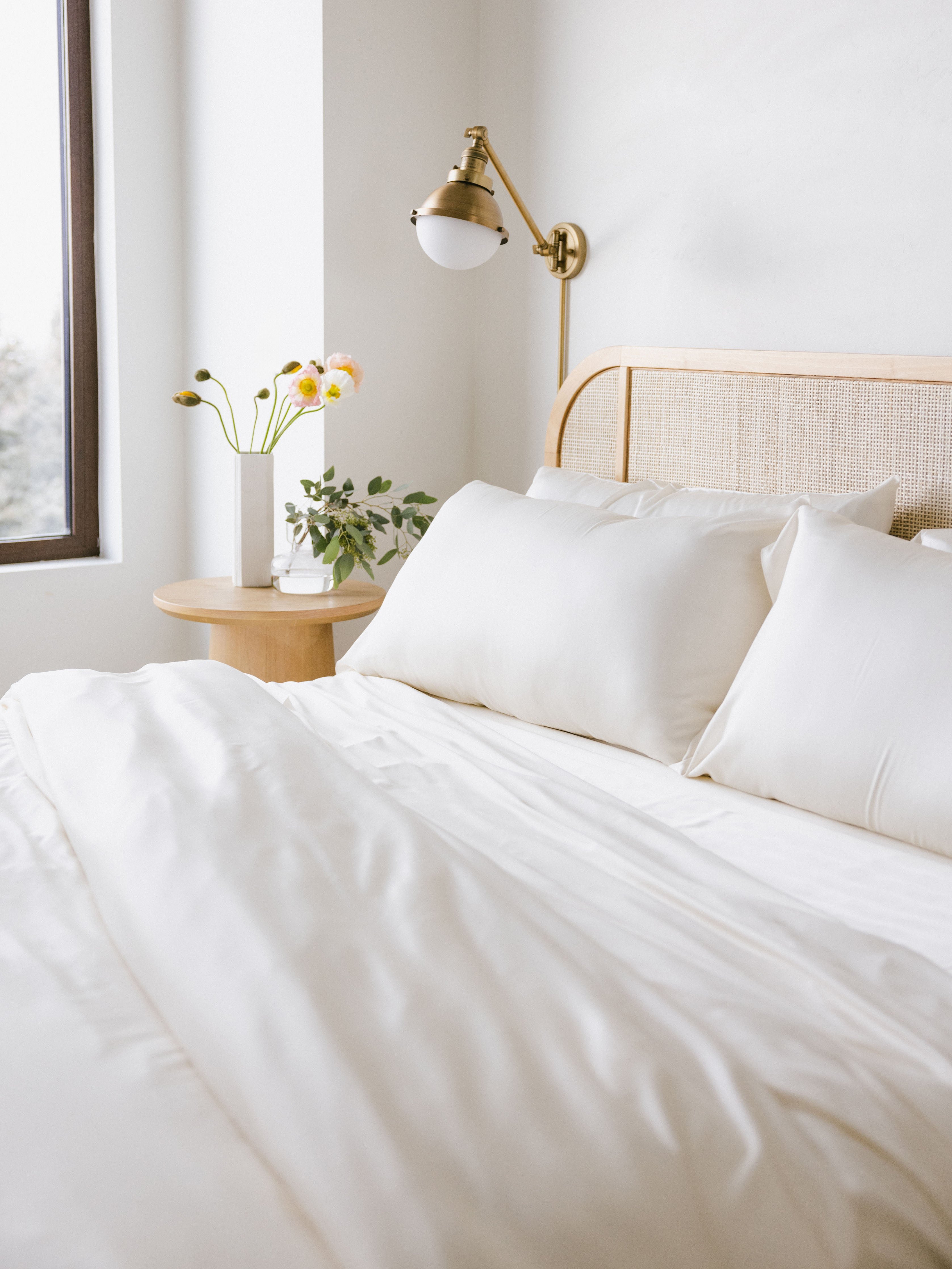 Partially made bed with creme bedding 