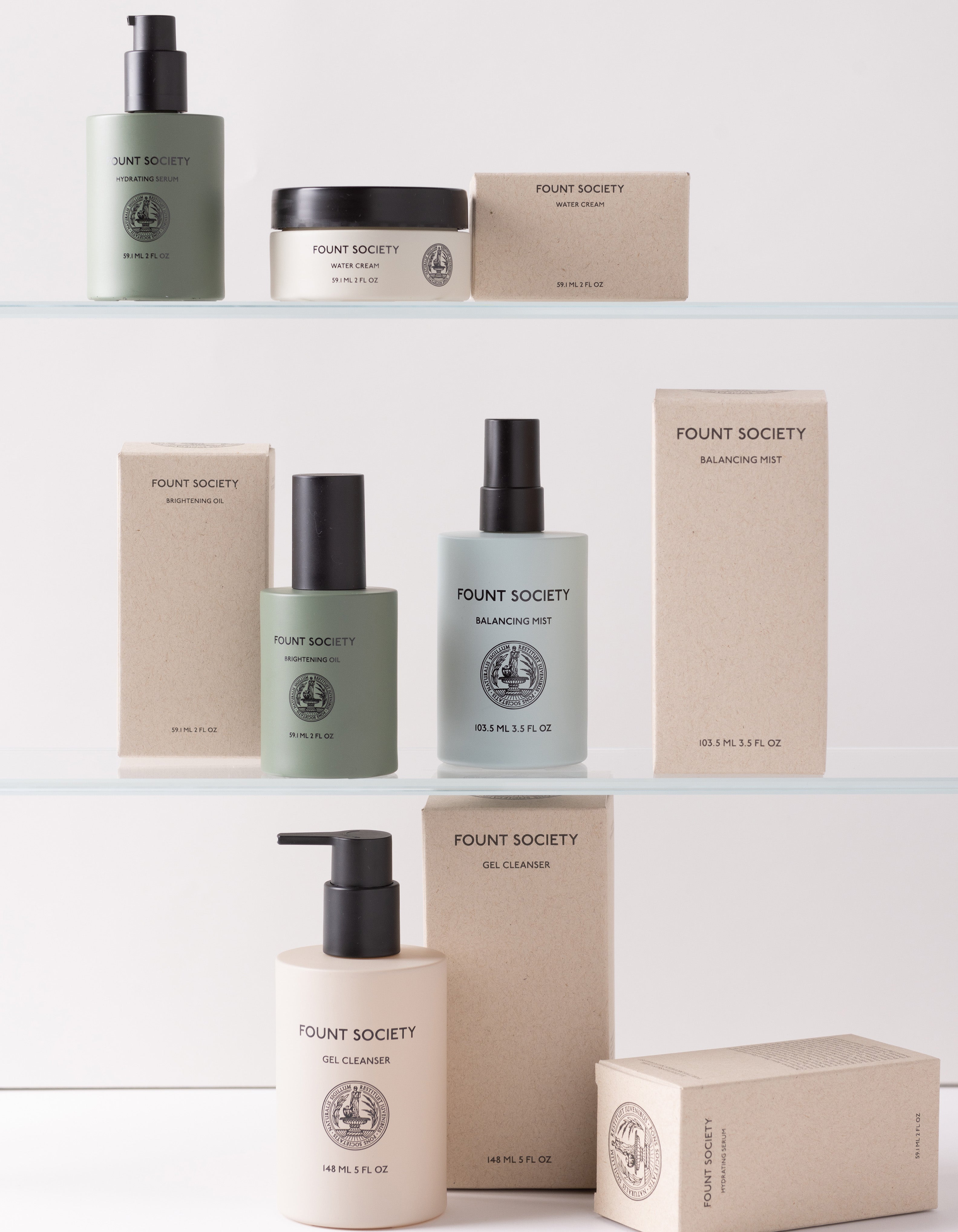 A display of Cozy Earth's The Routine skincare products on two shelves, featuring green and beige bottles, a white tub, and rectangular boxes. The items boast clean, minimalist packaging with a mix of pump bottles, spray bottles, and jars.