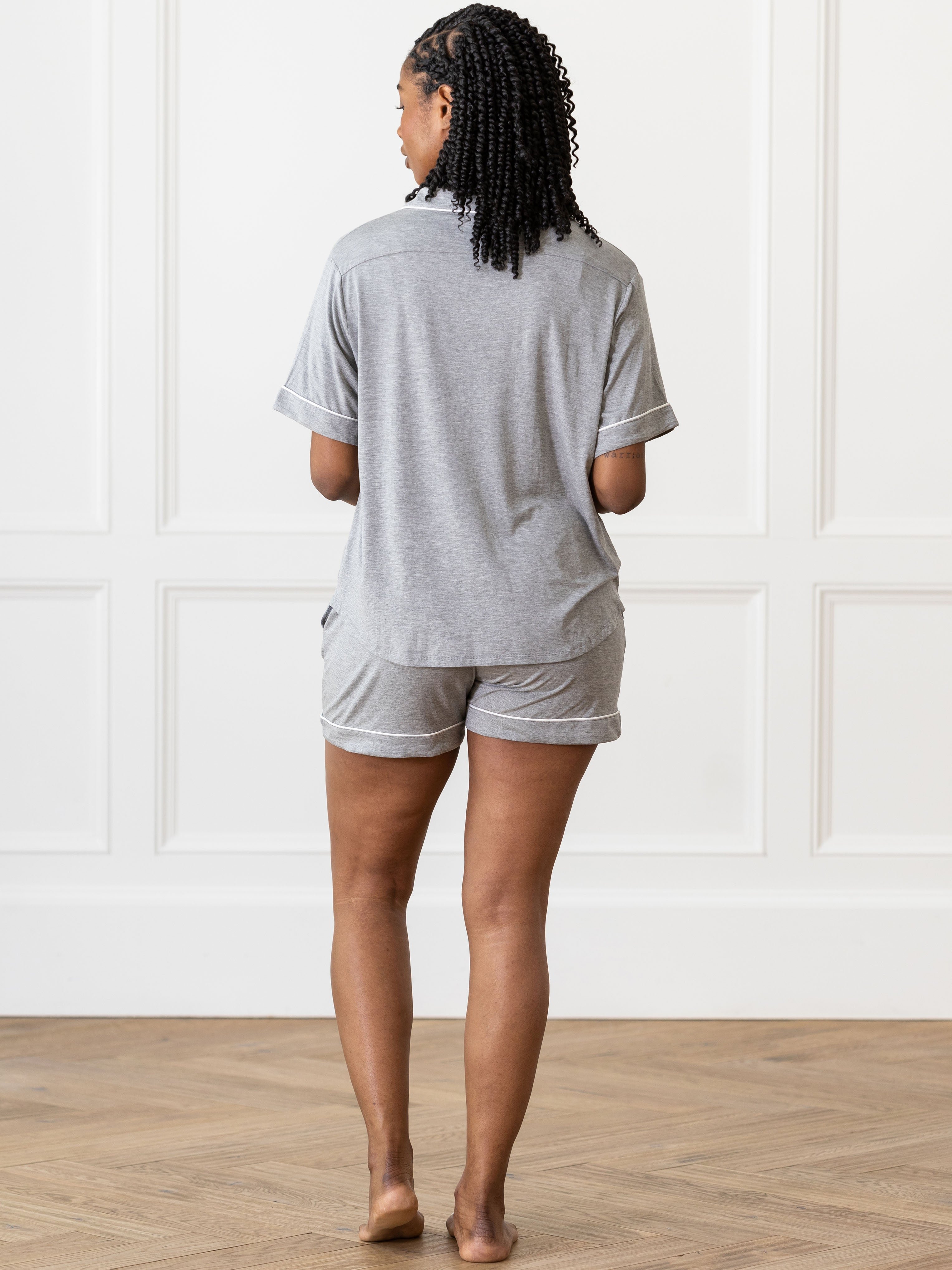Grey Short Sleeve Pajama Set modeled by a woman. The photo was taken in a light setting, showing off the colors and lines of the pajamas. 