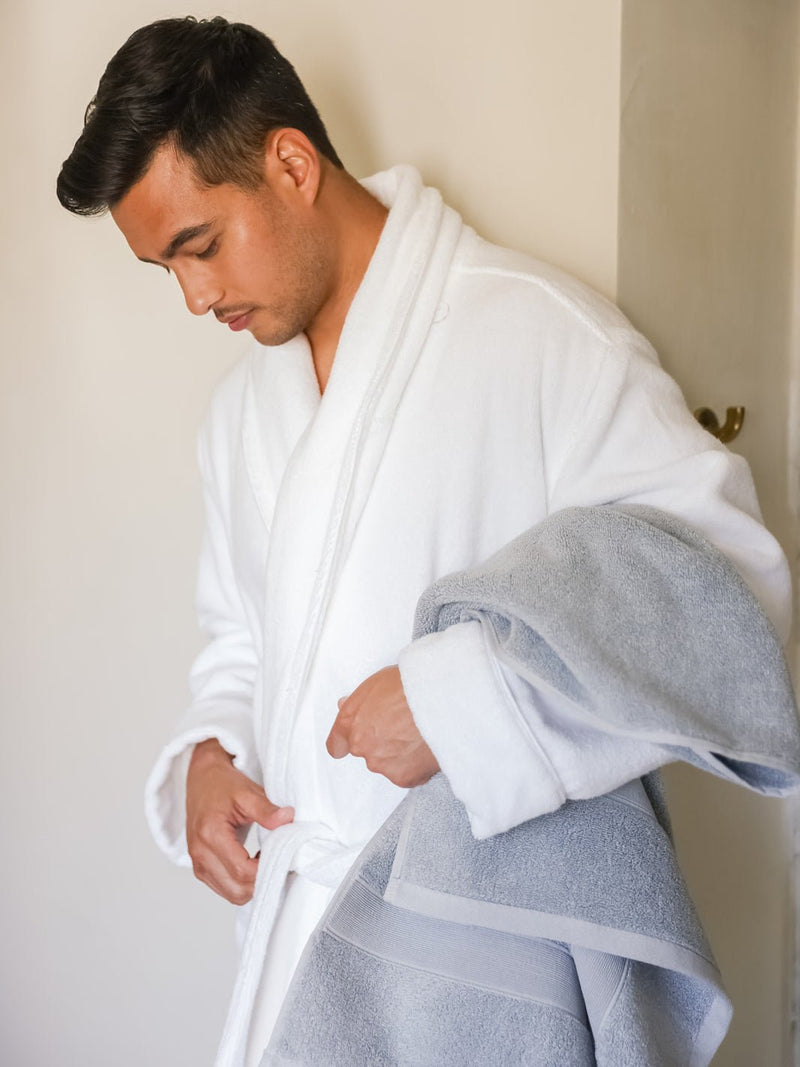 Mab in white robe holding harbor mist luxe bath sheet