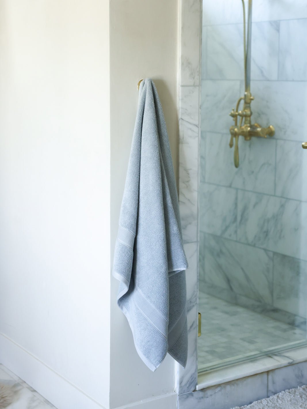 Harbor mist luxe bath sheet hanging next to shower 