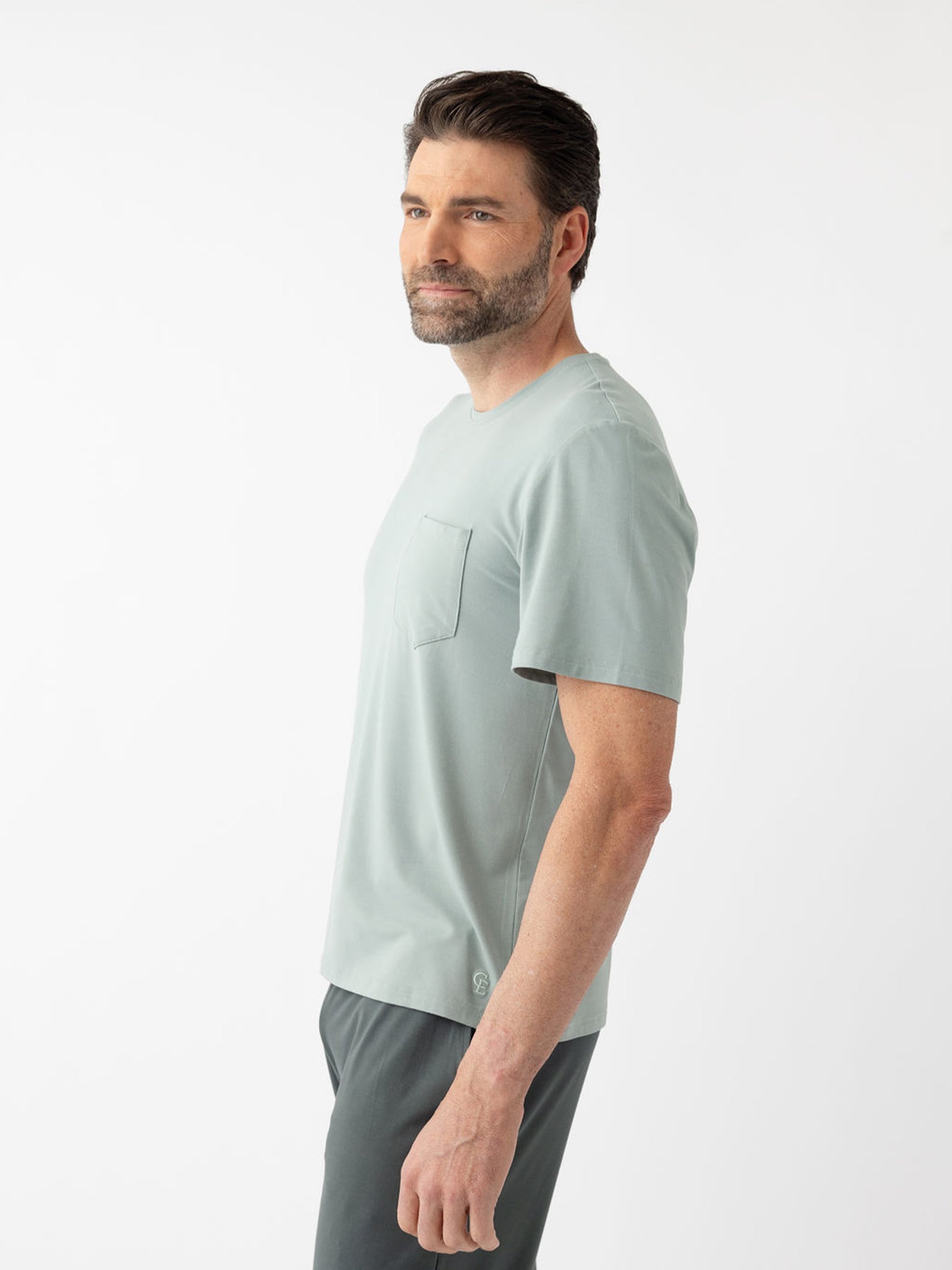 Side view of man wearing haze pajama shirt with white background 