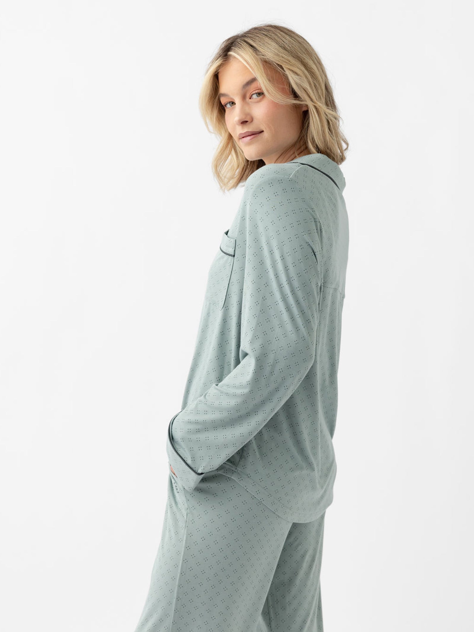 Side view of woman in haze diamond dot pajamas with white background 