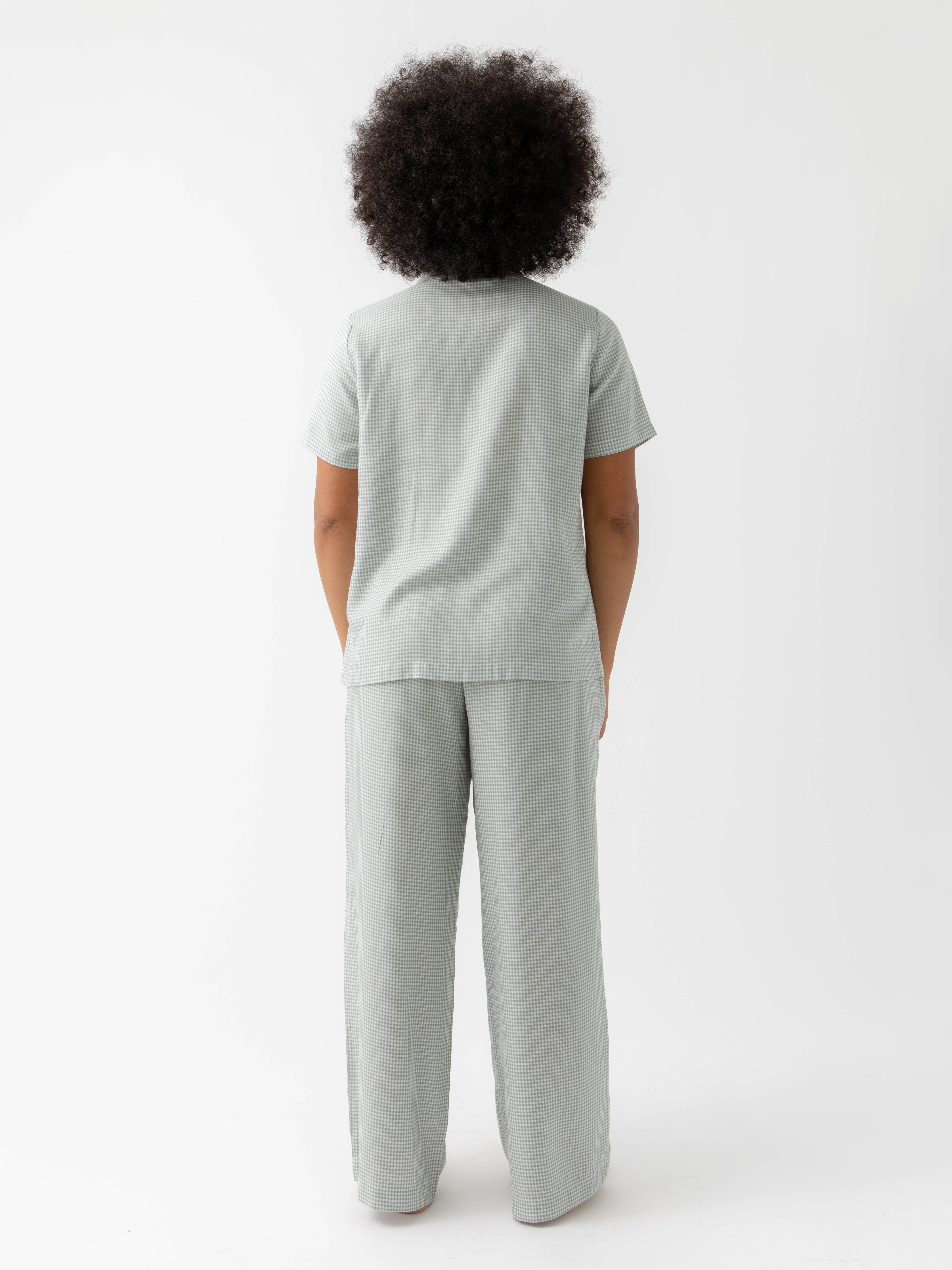 Back of woman in haze mini gingham pajama set with white background 