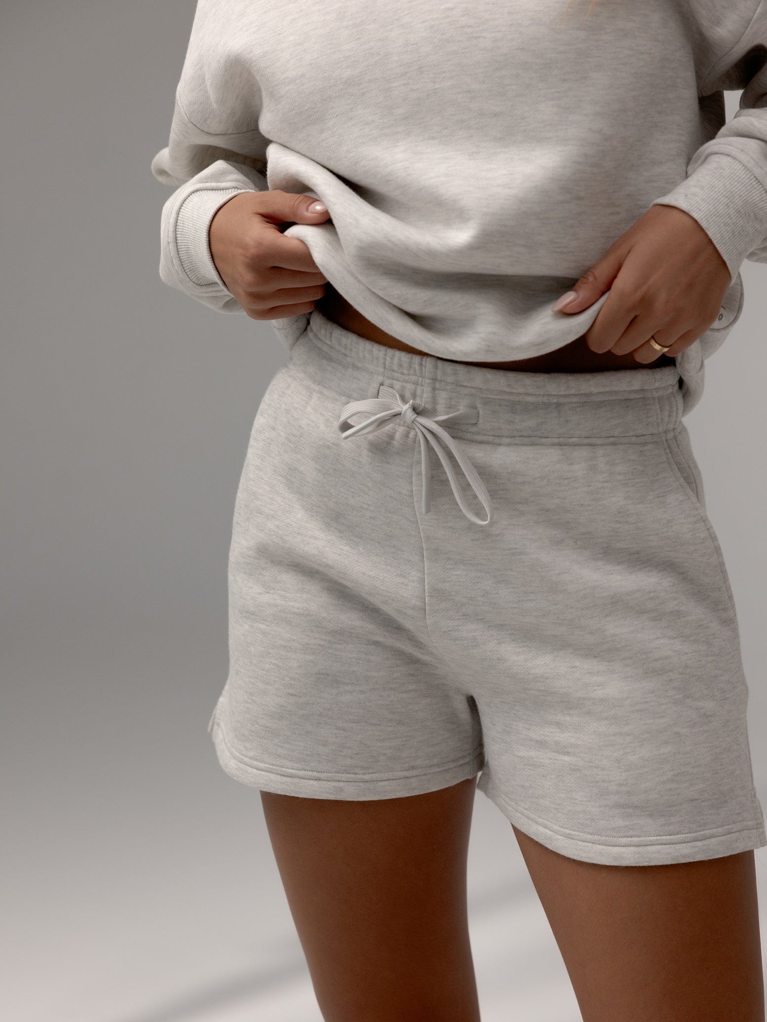 Heather Grey CityScape Shorts. The shorts are being worn by a female model. The background it a grey hue background. 