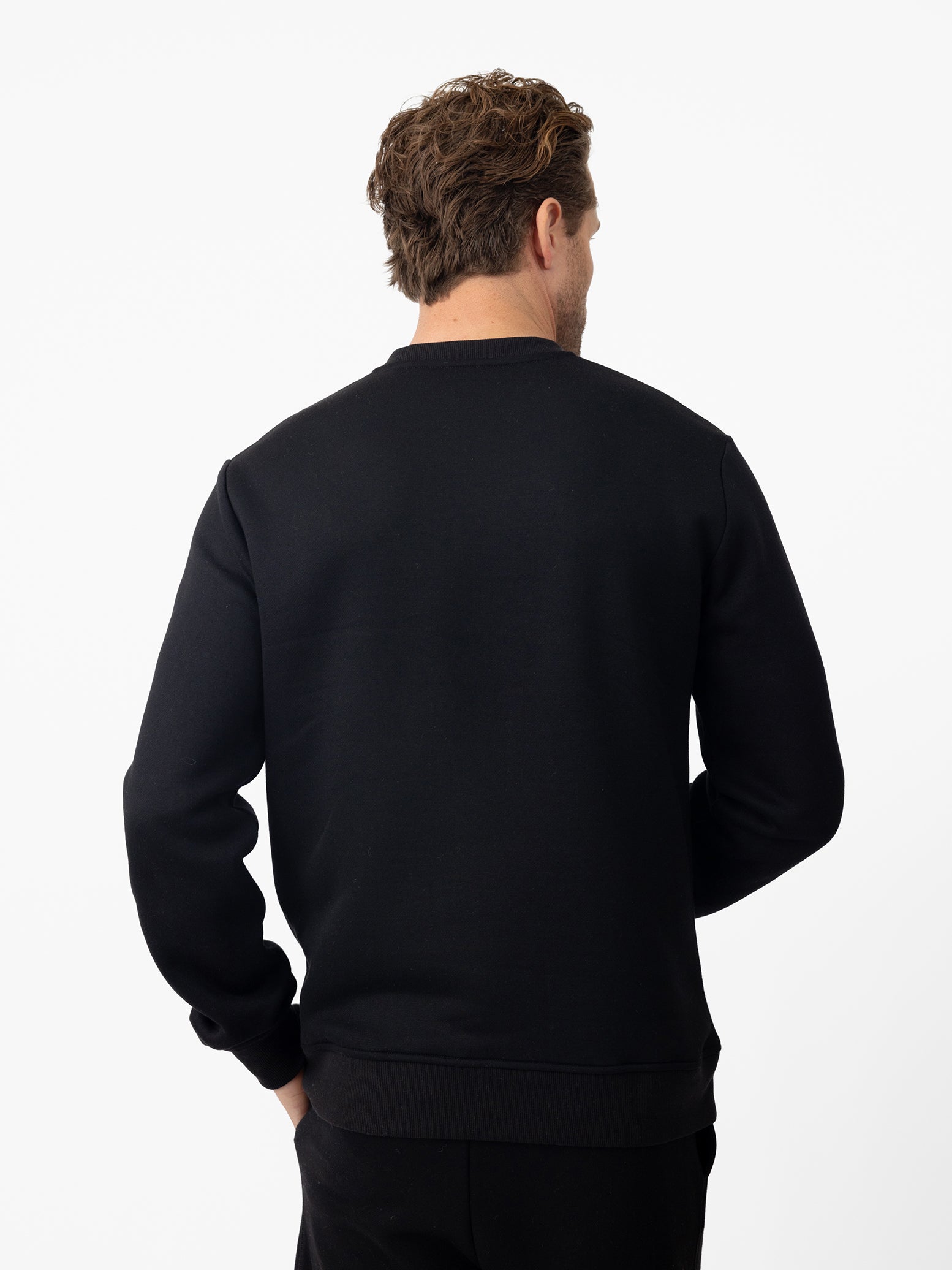 Back of man wearing black cityscape pullover with white background 