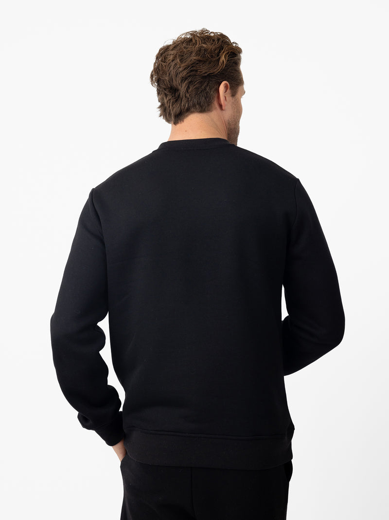 Back of man wearing black cityscape pullover with white background