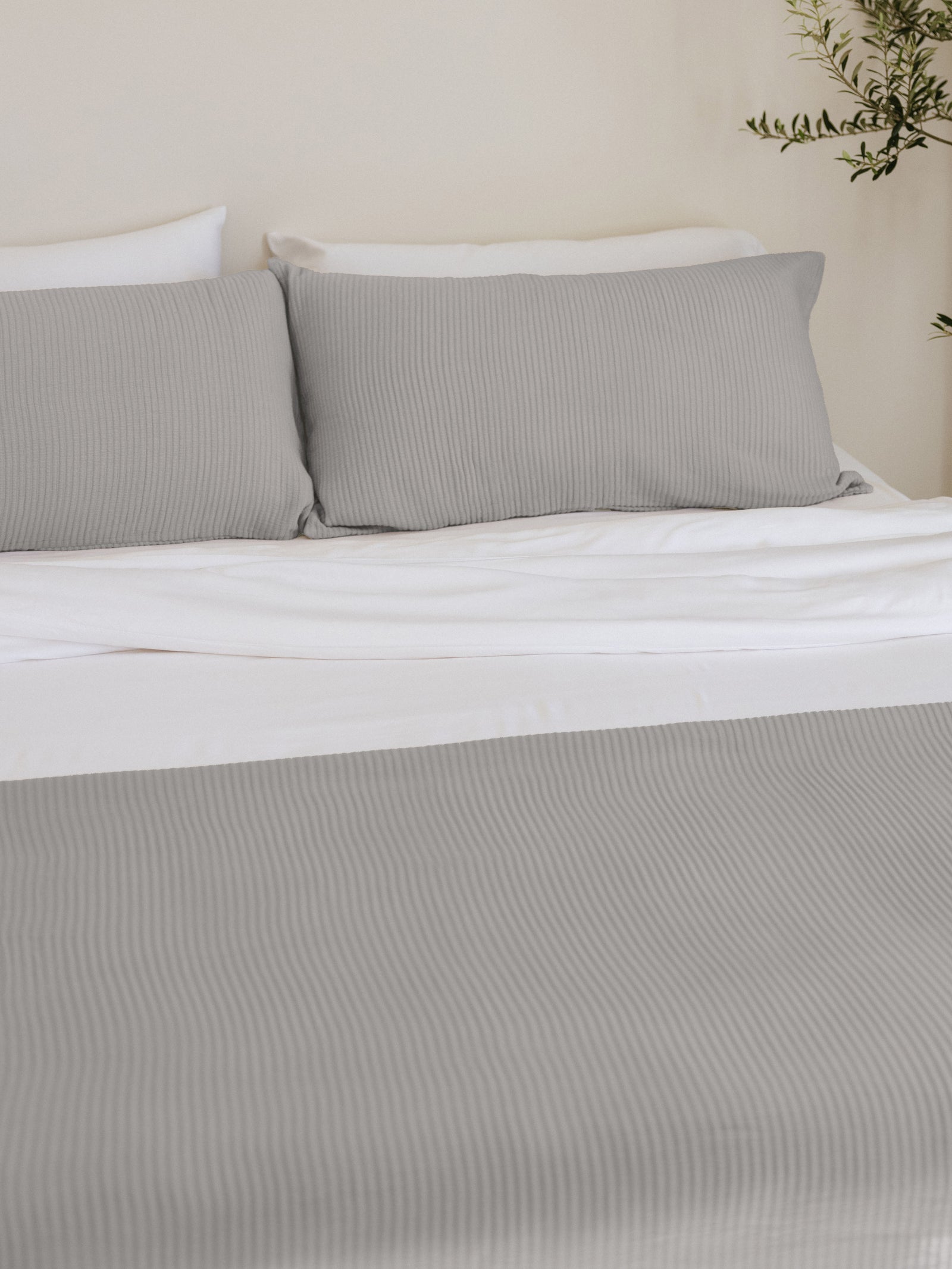 Light Grey coverlet and shams on a bed 