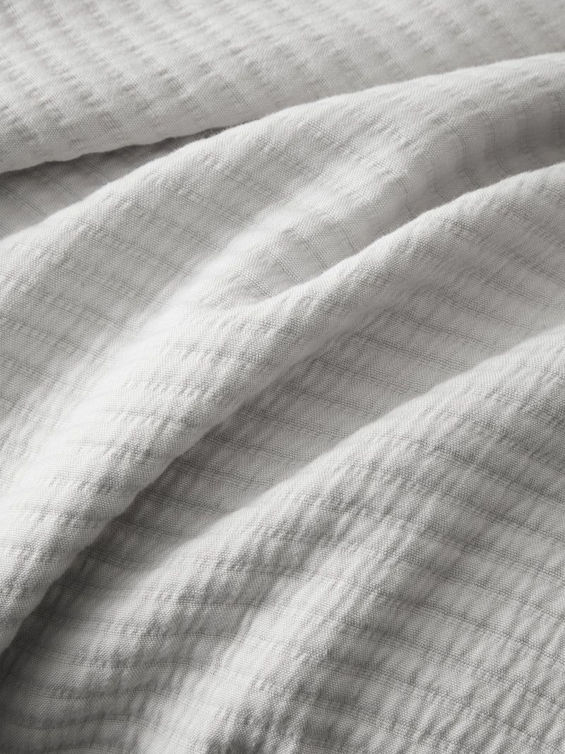 Close up of light grey coverlet fabric