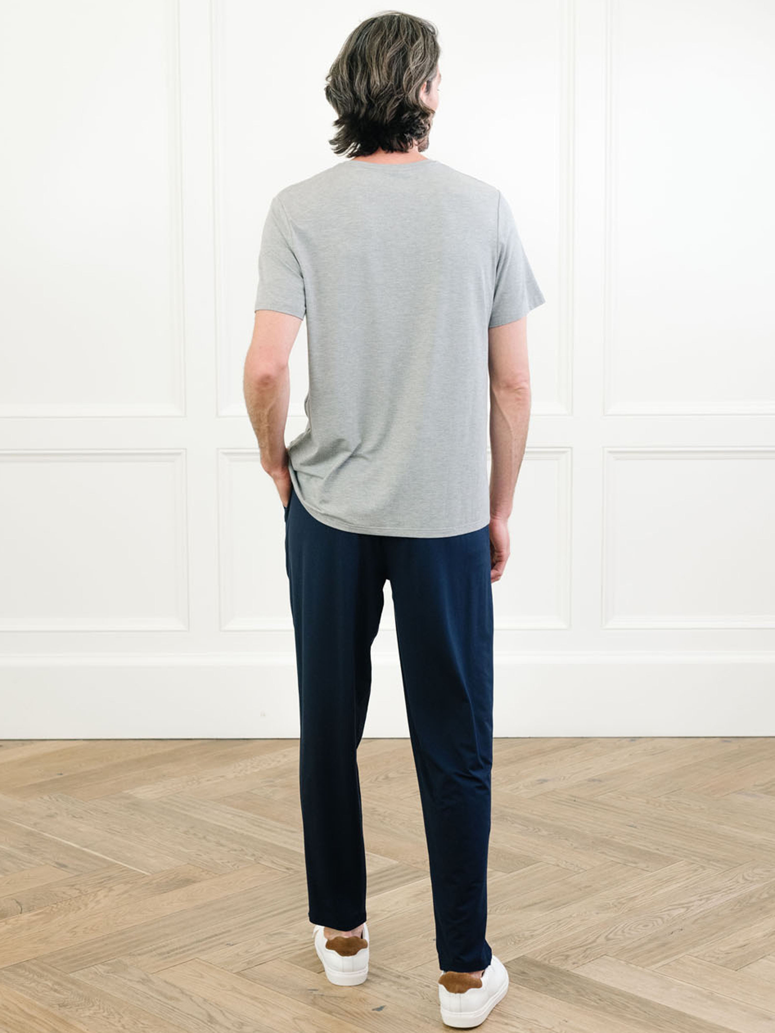 Heather grey Men's Stretch-Knit Bamboo Lounge Tee. A man is wearing the lounge tee in a well lit home with his back facing the camera.|Color:Heather Grey