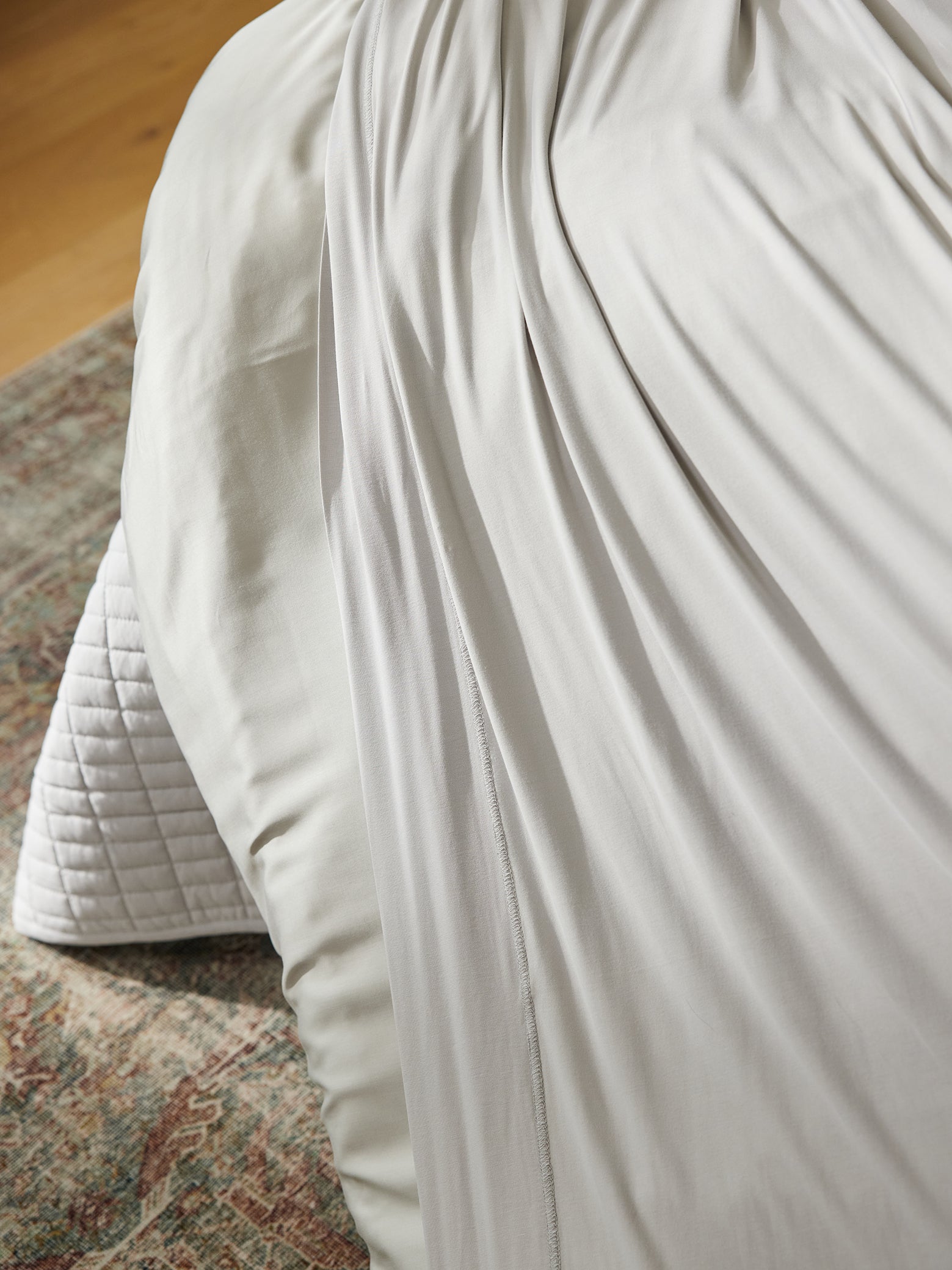 Close up of light grey bamboo jersey bedding on bed 