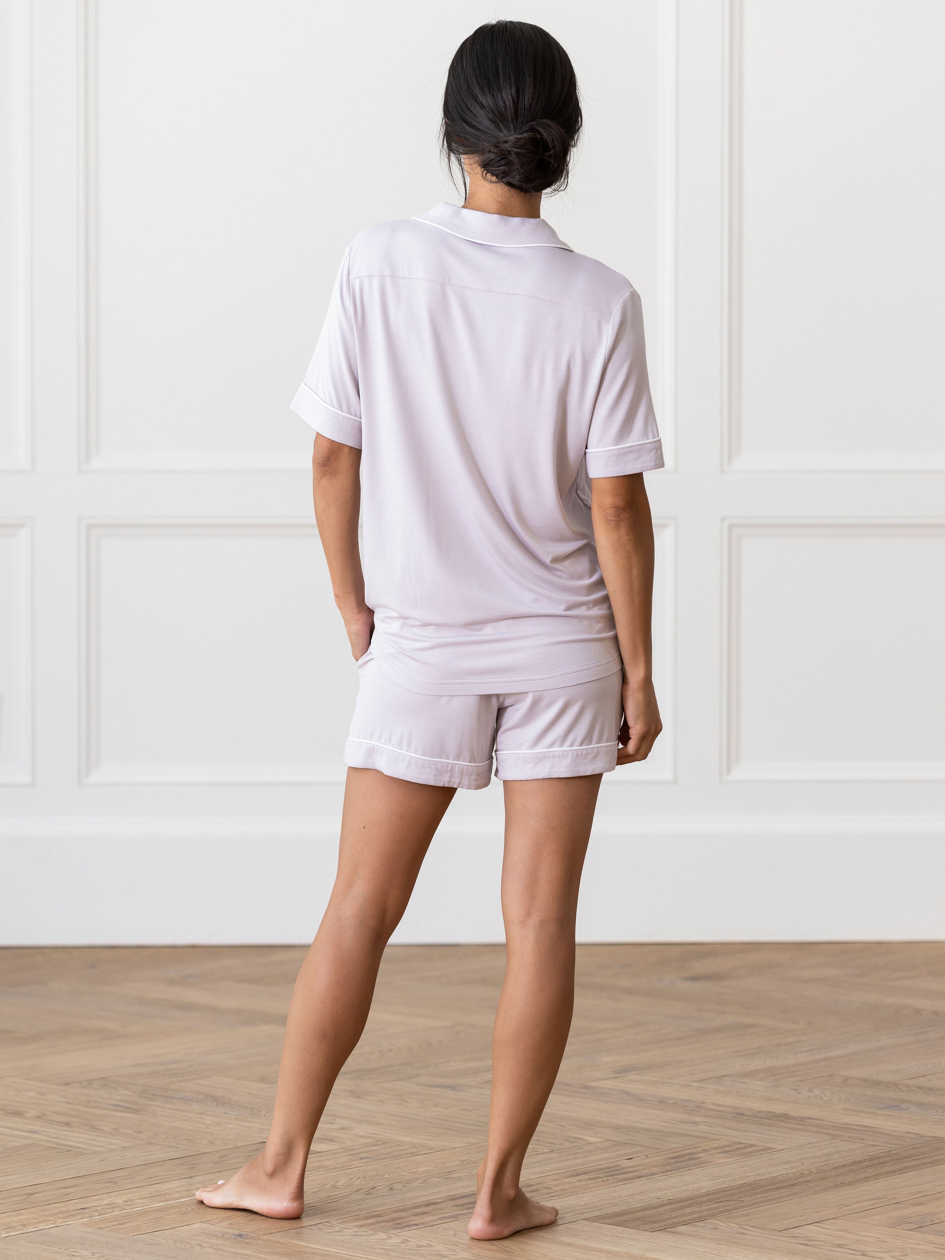 Lilac Short Sleeve Pajama Set modeled by a woman. The photo was taken in a light setting, showing off the colors and lines of the pajamas. 