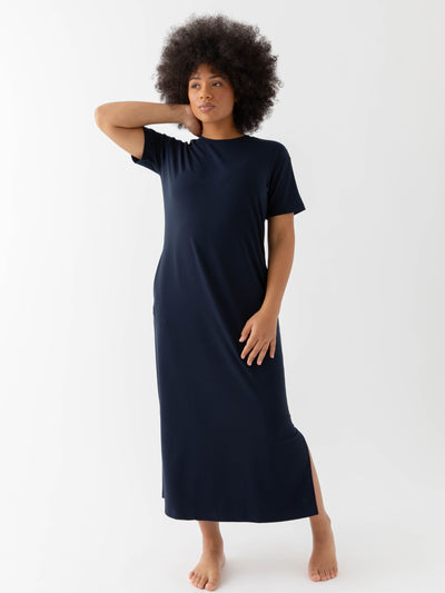 Navy Bamboo Midi Dress modeled by a woman. The photo was taken in a high contrast setting, showing off the colors and lines of the dress. |Color: Navy