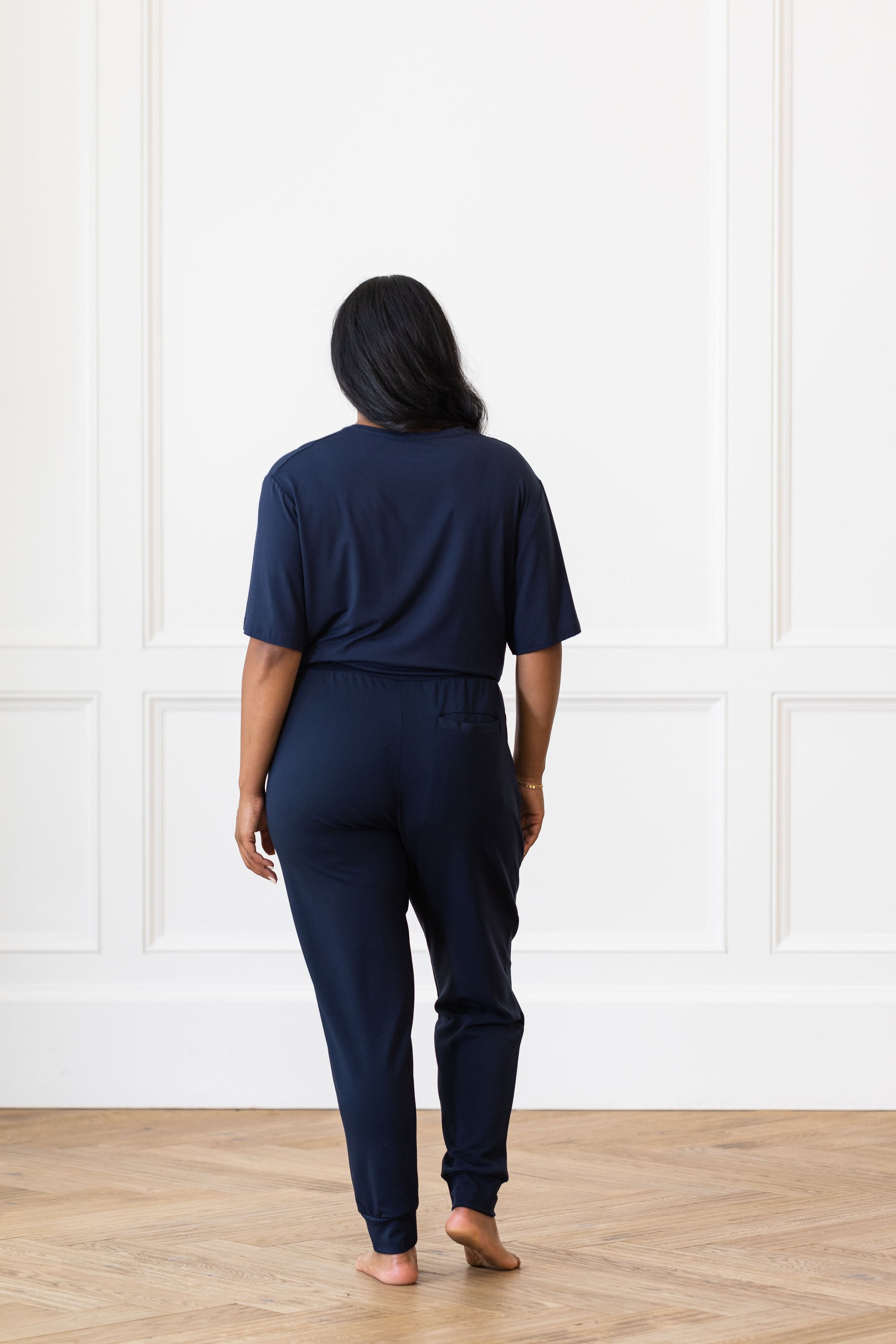 Woman wearing Cozy Earth Bamboo Lounge Tee in dark blue. She faces backward 