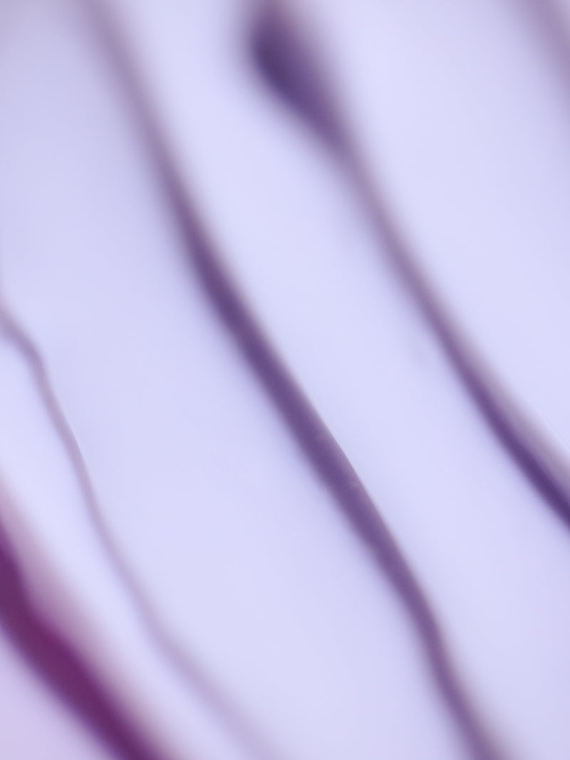 Close-up of soft purple and white abstract waves creates a smooth, flowing pattern with varying line thickness and shades, conveying movement and fluidity—ideal imagery for Cozy Earth's Night Cream.