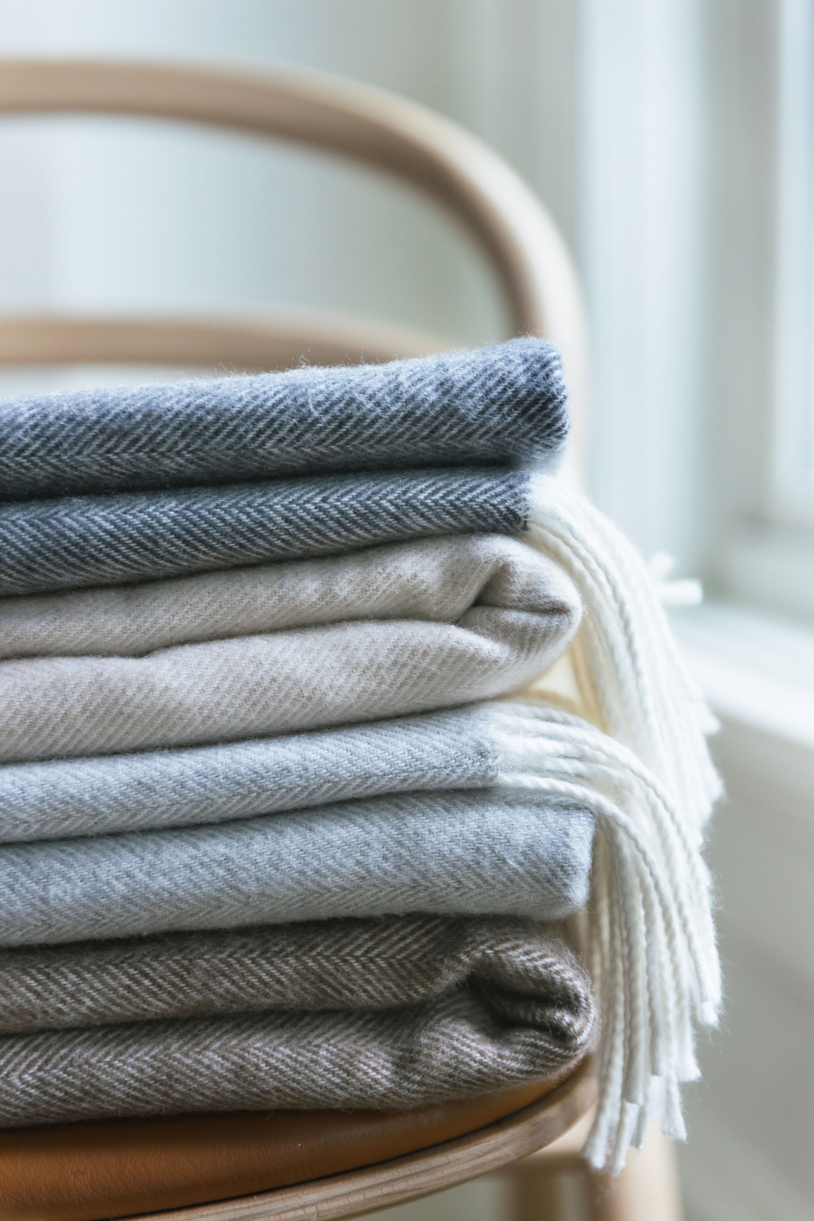 Four different colored throws folded on a chair |Color:Oatmeal
