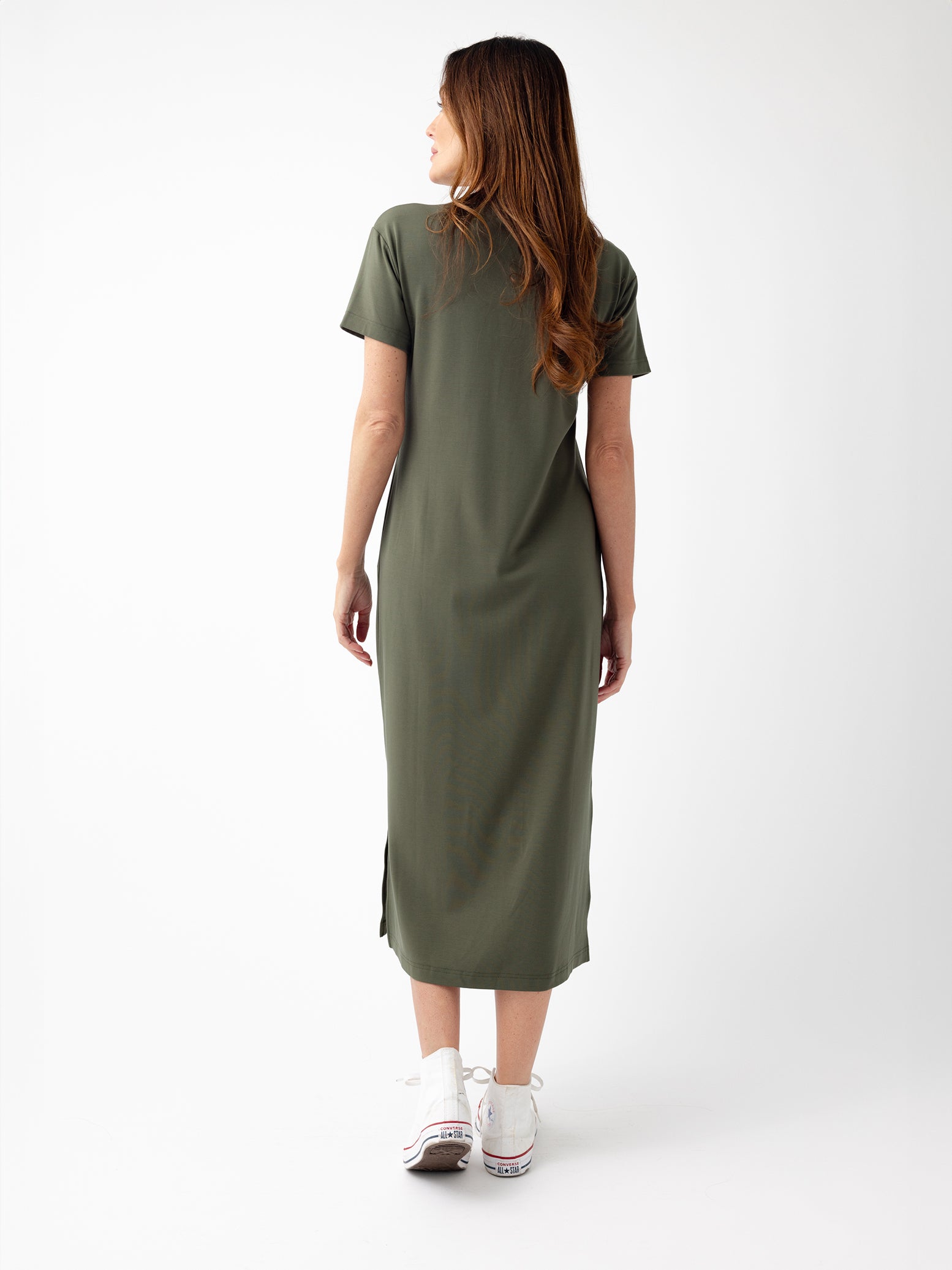 Back of woman in olive midi dress with white background 