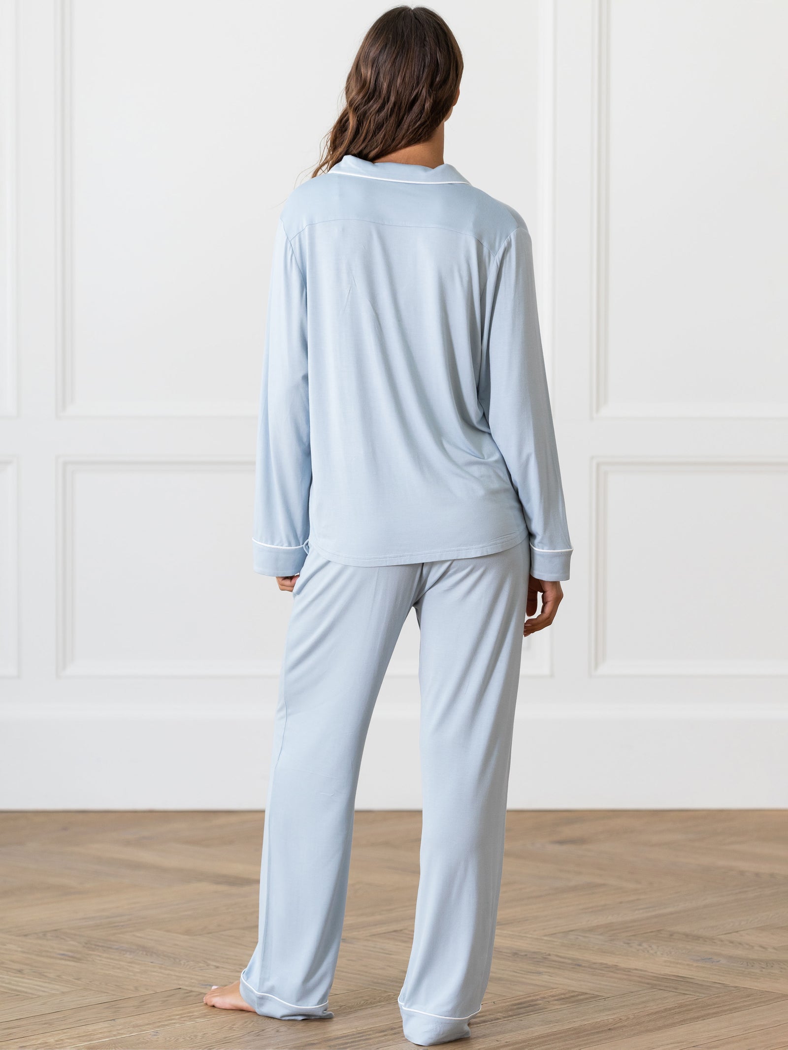 Powder Blue Long Sleeve Pajama Set modeled by a woman. The photo was taken in a high contrast setting, showing off the colors and lines of the pajamas. 