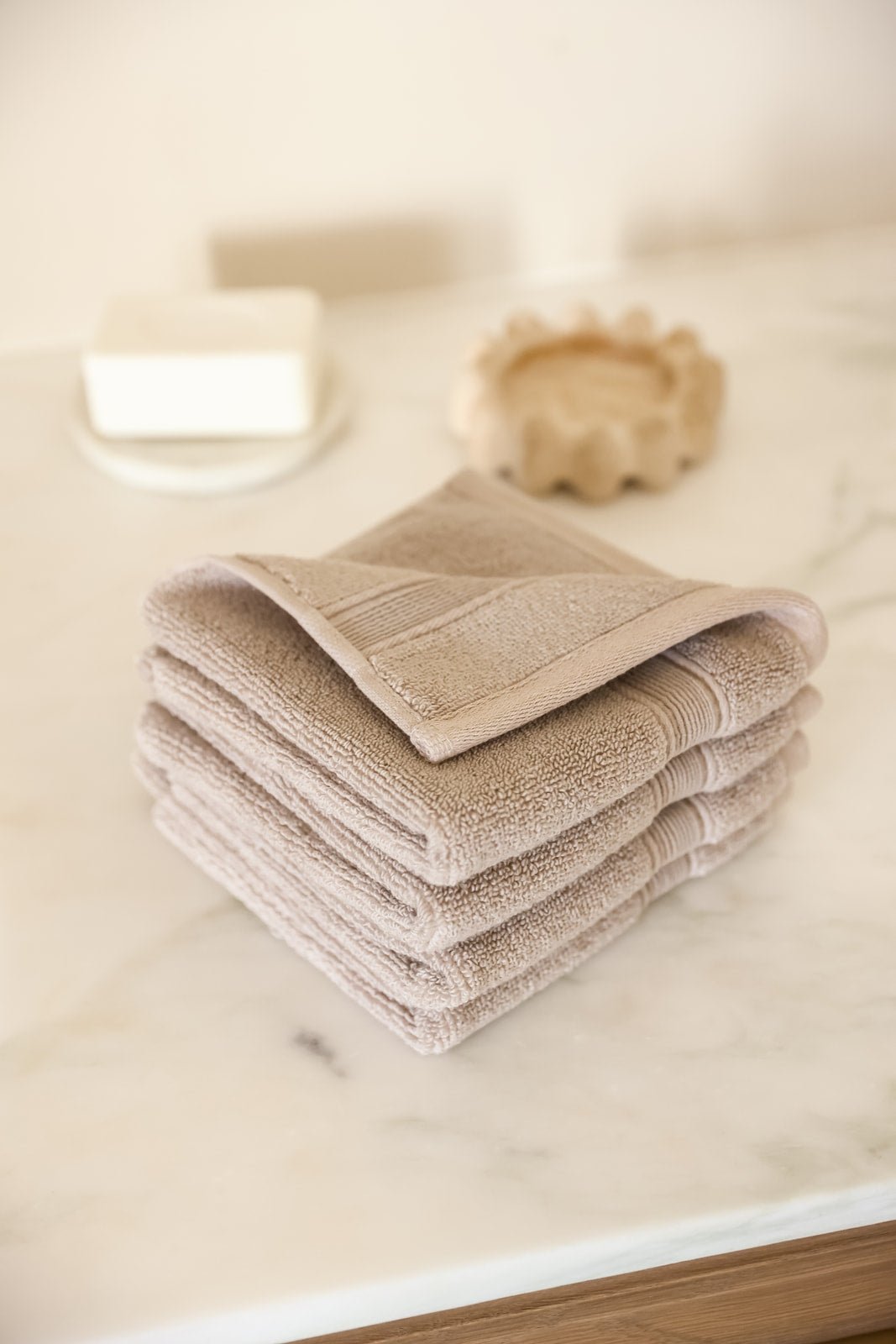 Sand washcloths folded on bathroom counter 