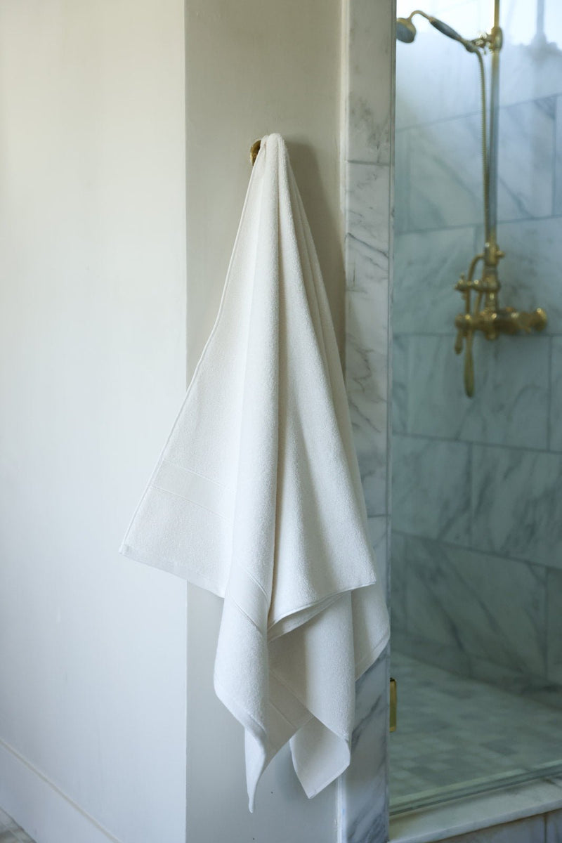 Seashell luxe bath towel hanging next to shower