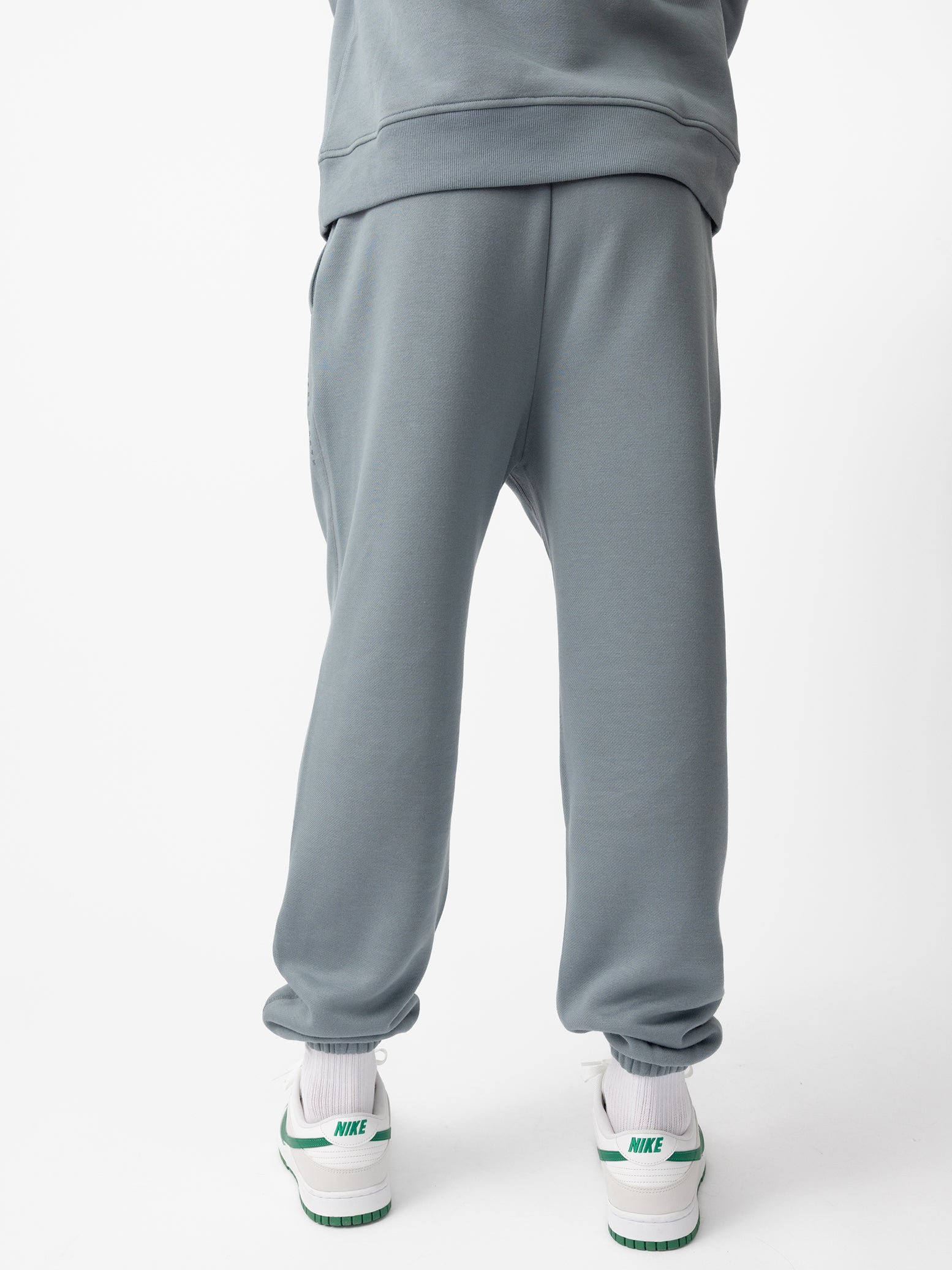 Back of man wearing smokey blue cityscape sweats 