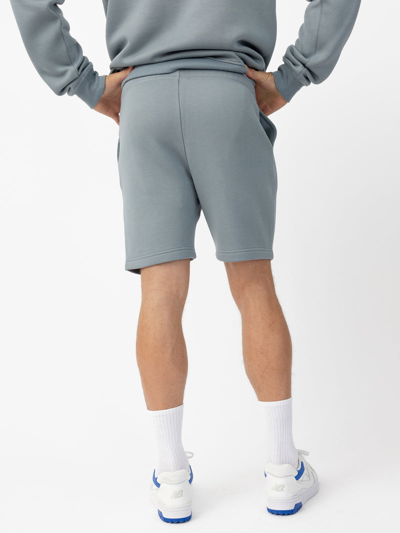 Man wearing Smokey Blue CityScape Shorts with white background
