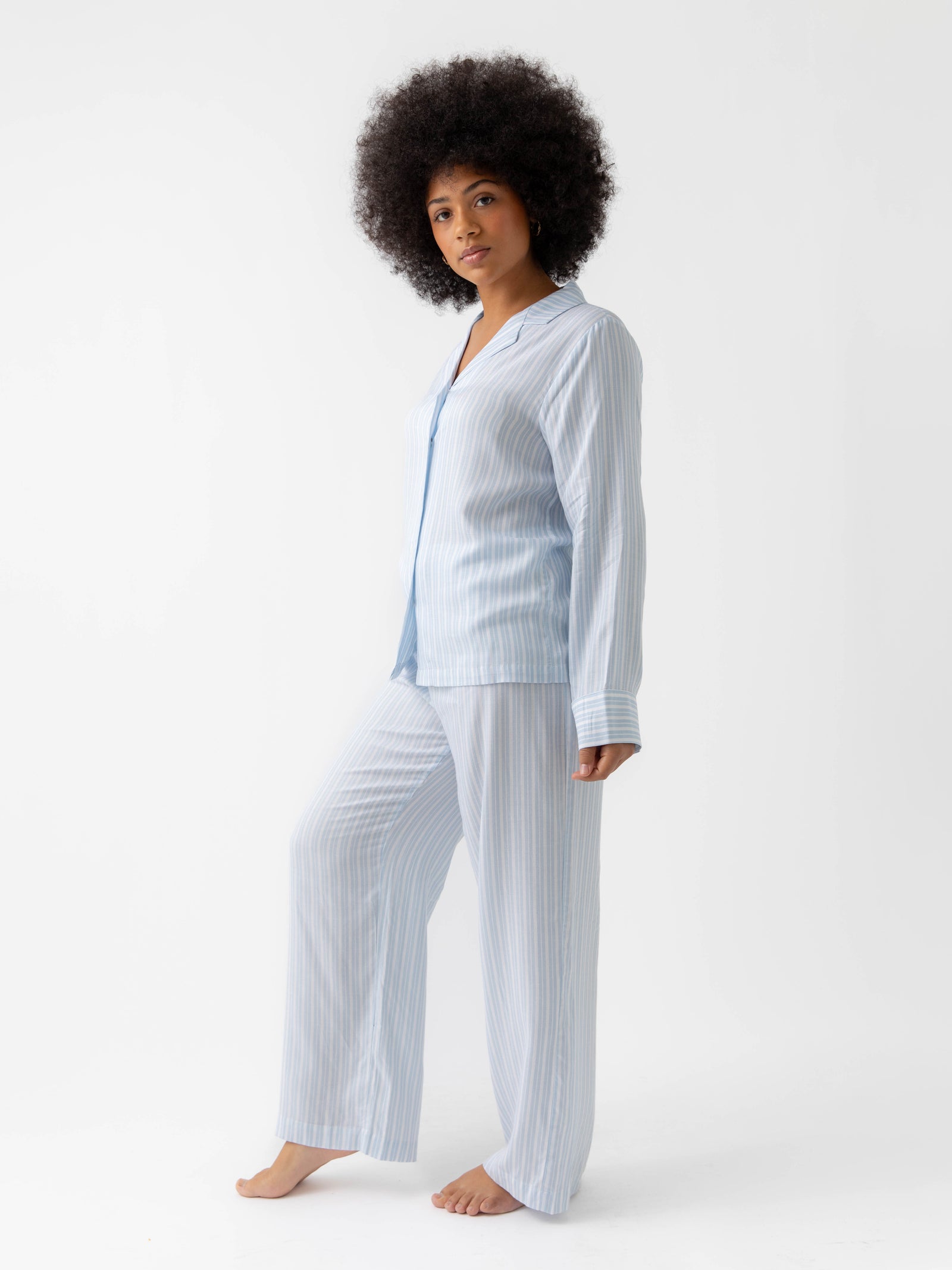 Woman wearing spring blue stripe pajama set with white background 