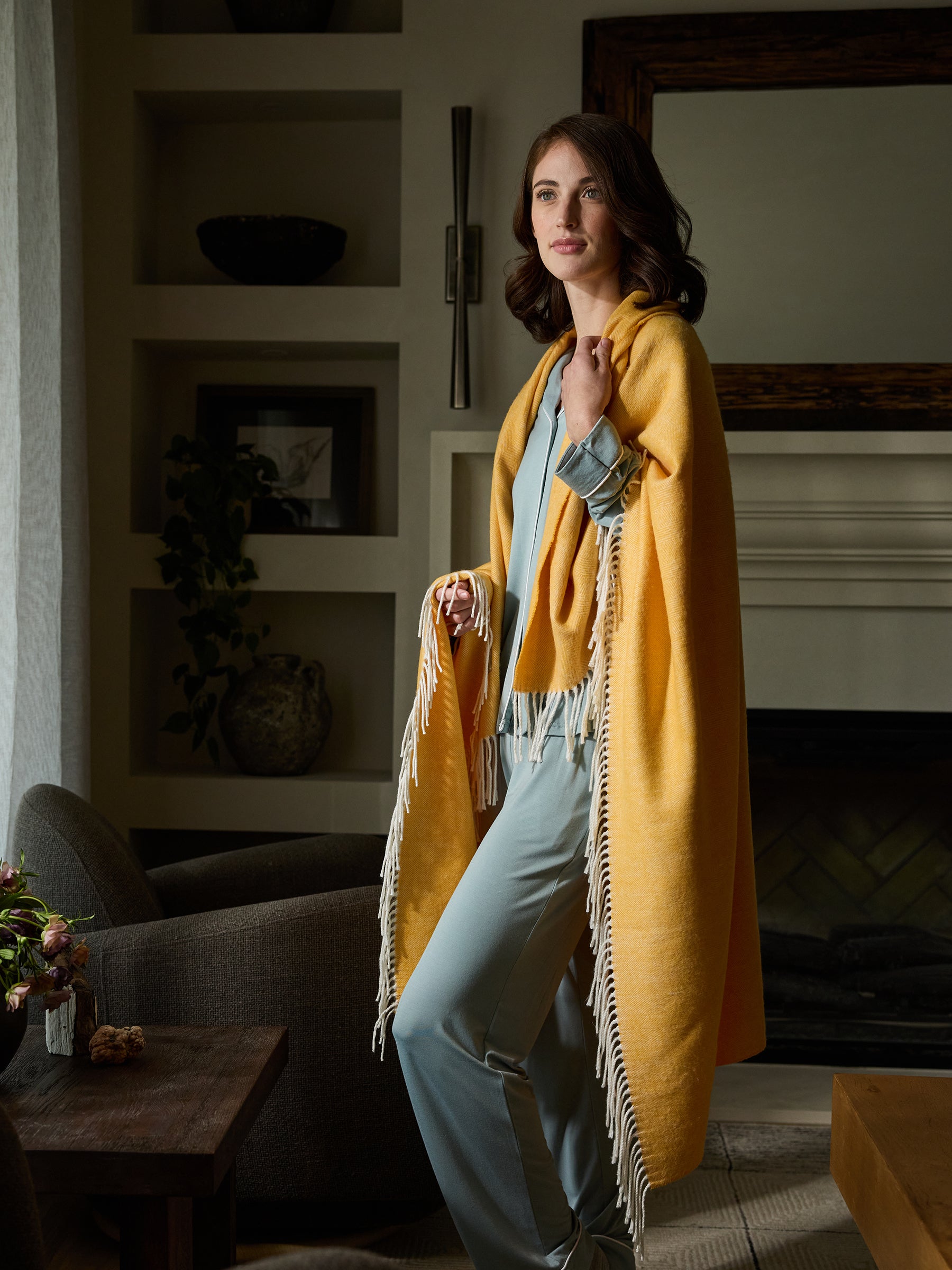 Woman standing with sunflower herringbone tassel throw wrapped around her 
