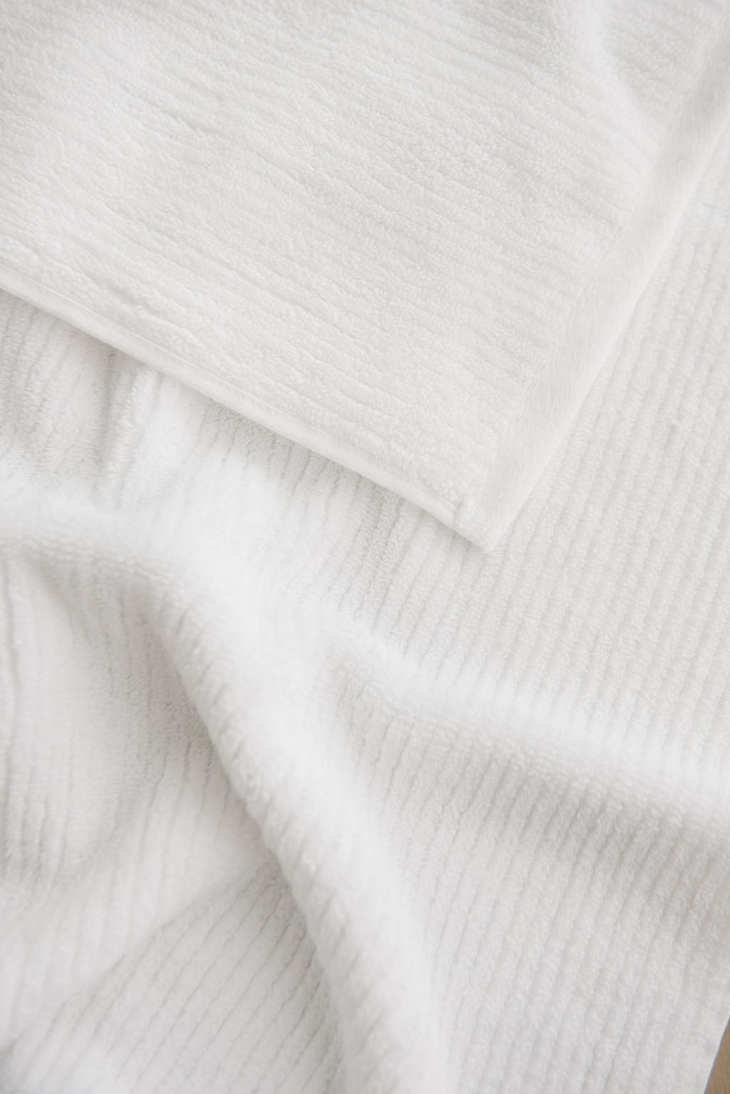 Ribbed Terry Hand Towel in the color White. Photo of Ribbed Terry Hand Towel taken as a close up of the towel. Only the towel is seen. 