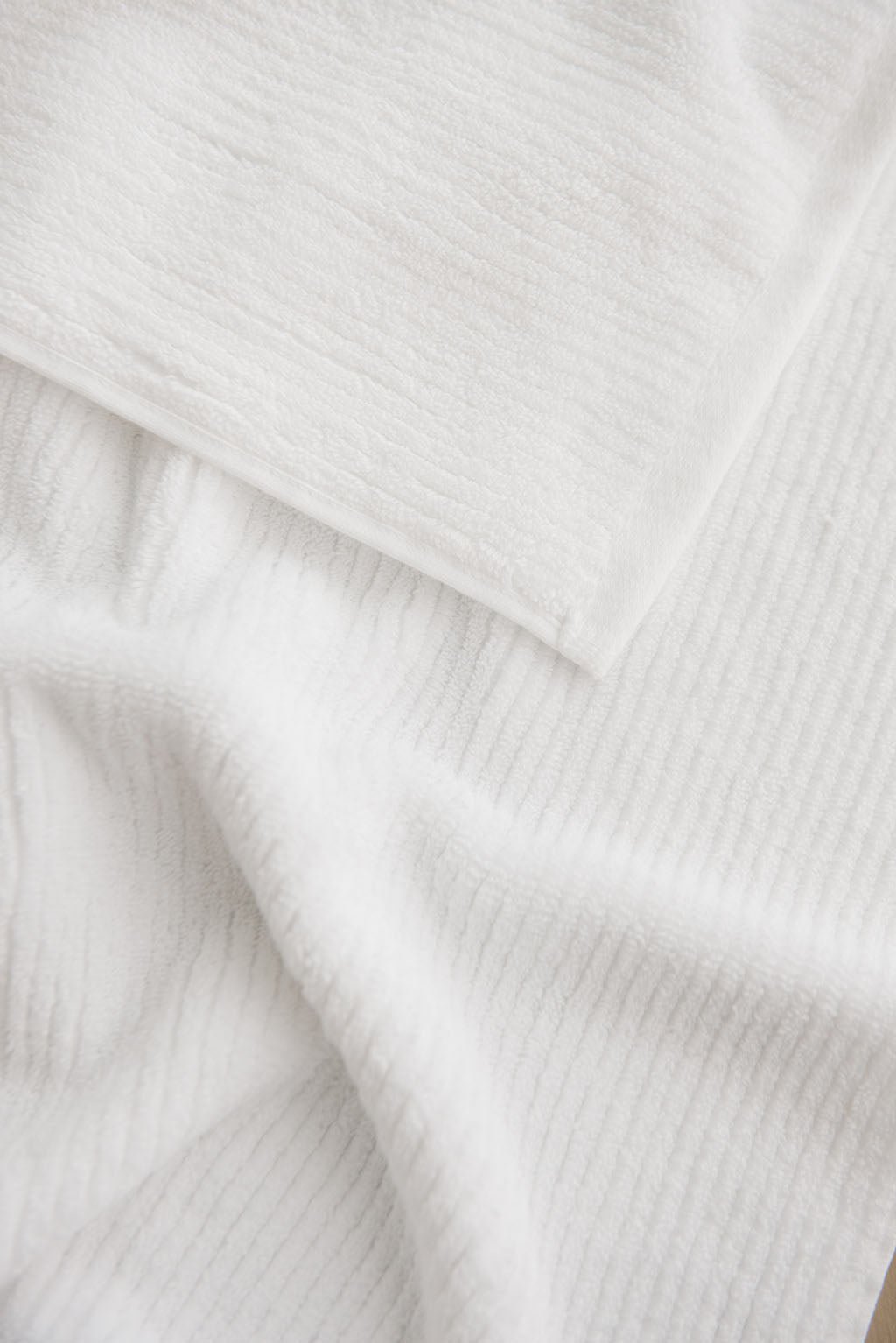 Ribbed Terry Hand Towel in the color White. Photo of Ribbed Terry Hand Towel taken as a close up of the towel. Only the towel is seen. 