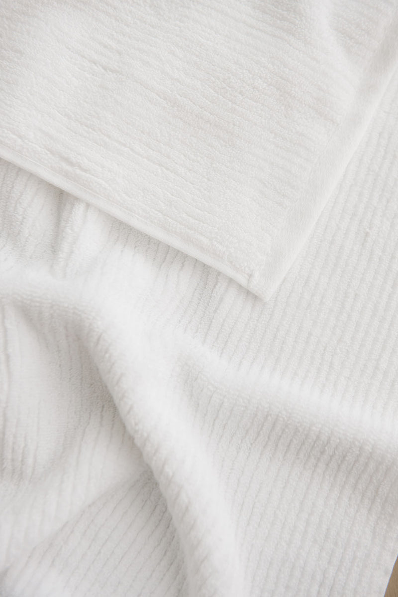 Ribbed Terry Hand Towel in the color White. Photo of Ribbed Terry Hand Towel taken as a close up of the towel. Only the towel is seen.