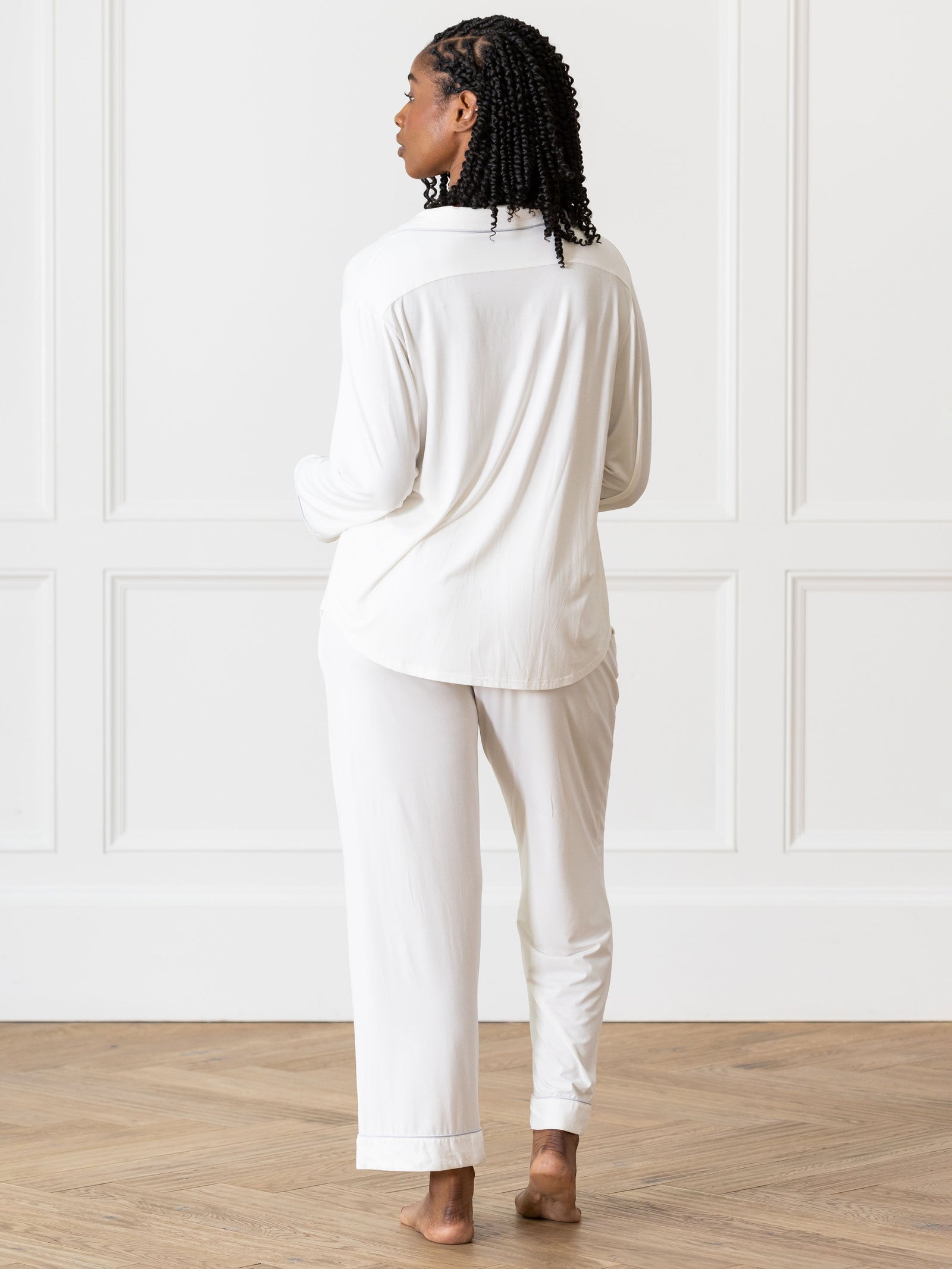 Ivory Long Sleeve Pajama Set modeled by a woman. The photo was taken in a high contrast setting, showing off the colors and lines of the pajamas. 