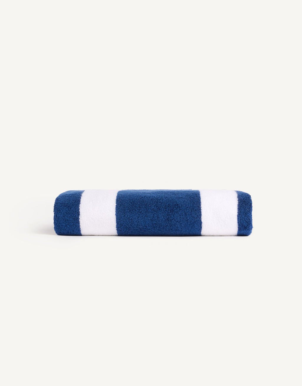 The Classic Stripe Resort Towel by Cozy Earth is rolled with blue and white stripes on a light gray background. |Color:Pacific