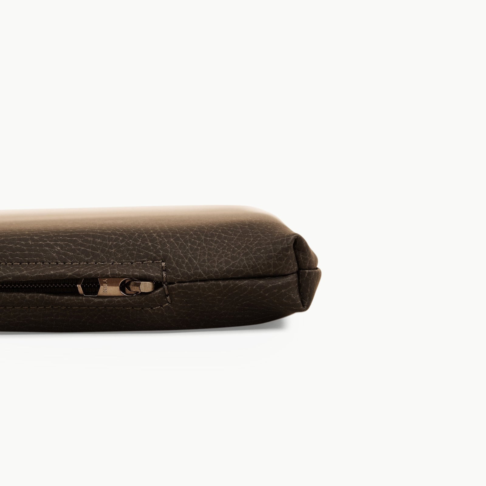 Close-up of the Gathre Wholesale Padded Changing Mat, highlighting its texture and stitching, with a visible zipper and a partial view of the brown leather surface against a white background.