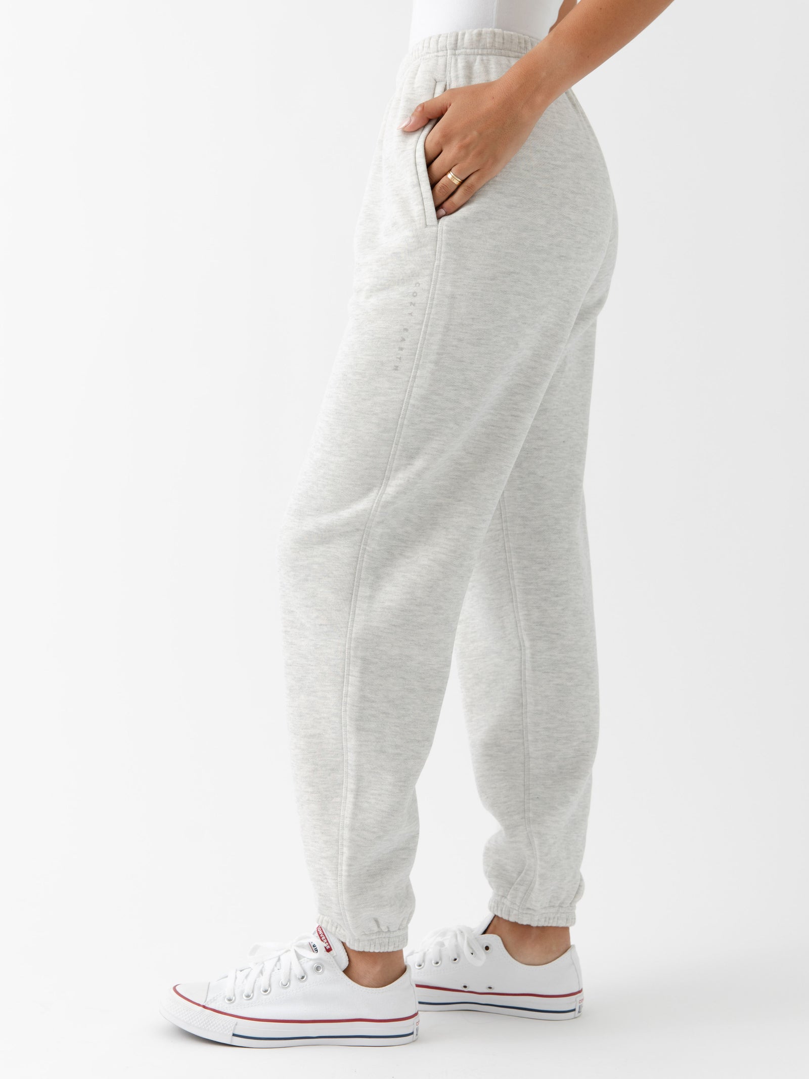 Heather Grey CityScape Joggers. The Joggers are being worn by a female model. The photo is taken from the waist down with the models hand in the pocket of the joggers. The back ground is white. 