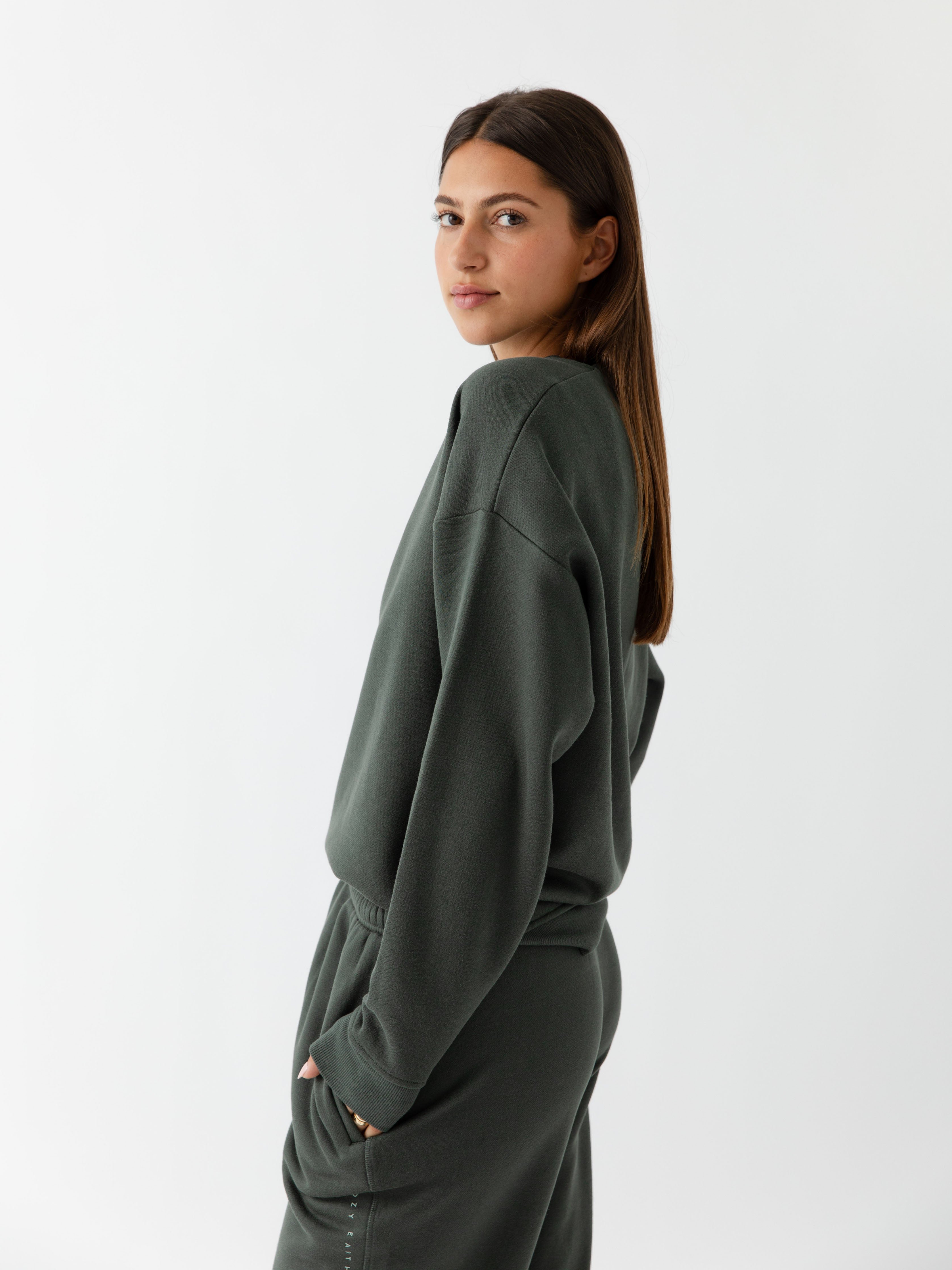 Storm CityScape Pullover Crew. The Pullover is being worn by a female model. Accompanying city scape clothing is being worn to complete the look of the outfit. The photo was taken with a white background. 