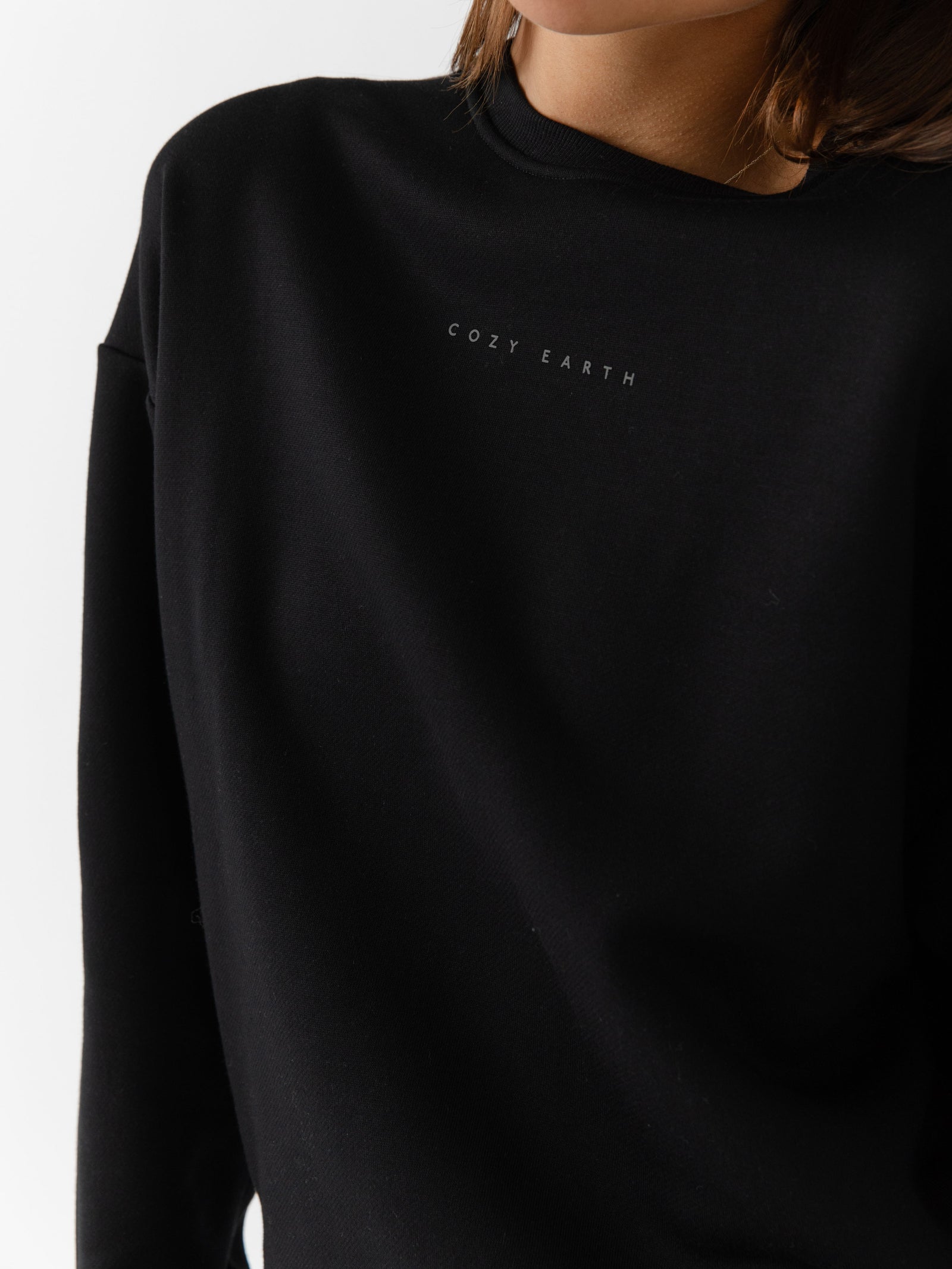 Black CityScape Pullover Crew. The Pullover is being worn by a female model. The photo was taken with a white background. 