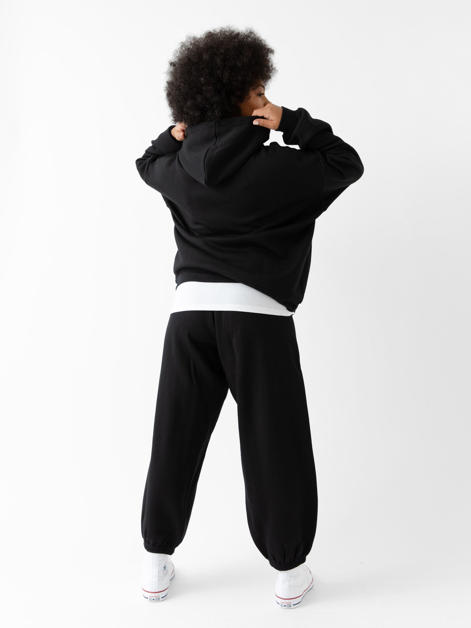 Back of woman wearing black cityscape hoodie set with white background 
