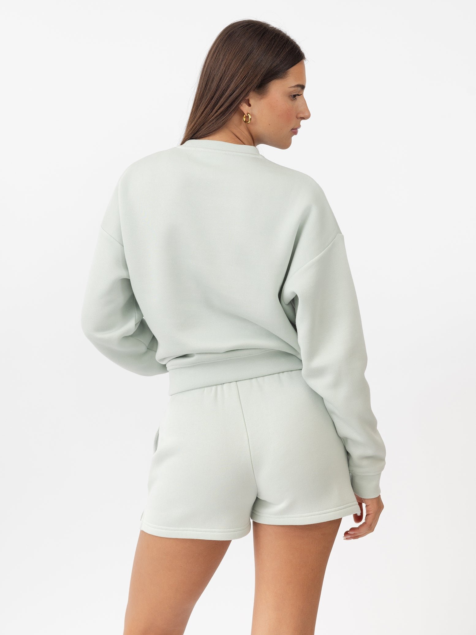 Arctic CityScape Pullover Crew. The Pullover is being worn by a female model. Accompanying city scape clothing is being worn to complete the look of the outfit. The photo was taken with a white background. 