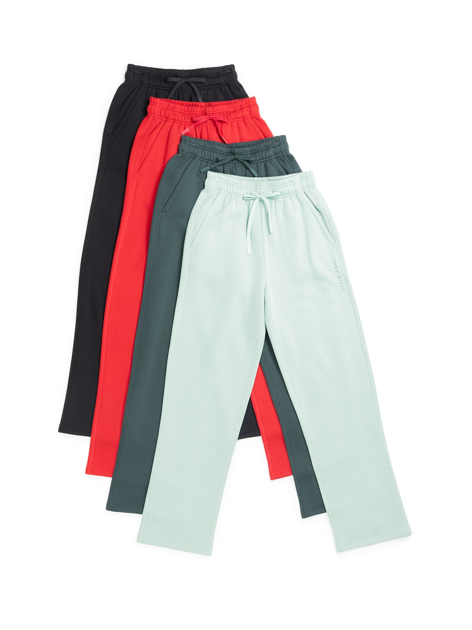 A stack of four pairs of the Women's CityScape Wide Leg Pant by Cozy Earth in a range of colors: light green, dark green, red, and black. Each pair is designed with a drawstring waistband and side pockets. They are neatly layered to create a color gradient. 