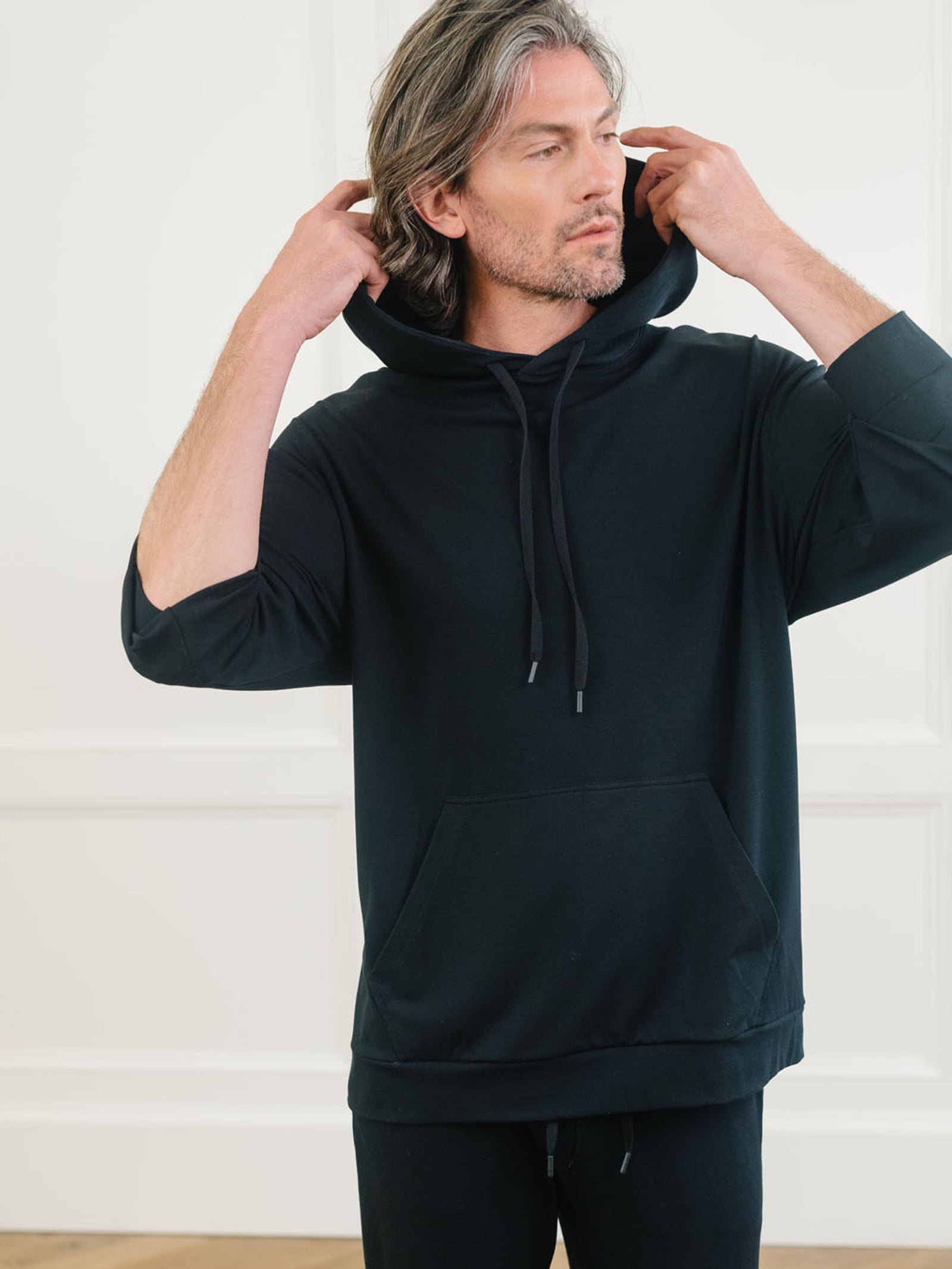 Black Bamboo Hoodie worn by man standing in front of white background.