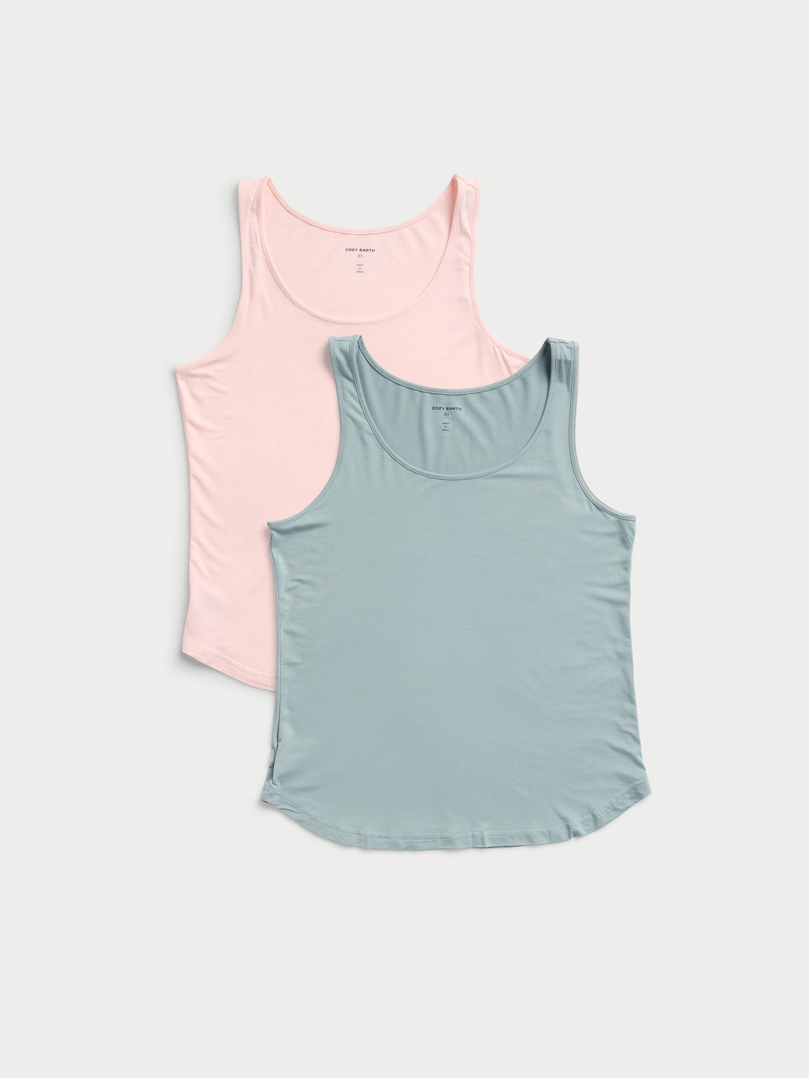 Two Women's Stretch-Knit Bamboo Lounge Tanks by Cozy Earth are laid flat. The top one is light pink, and the bottom one is a soft teal color, both featuring a scoop neckline. 