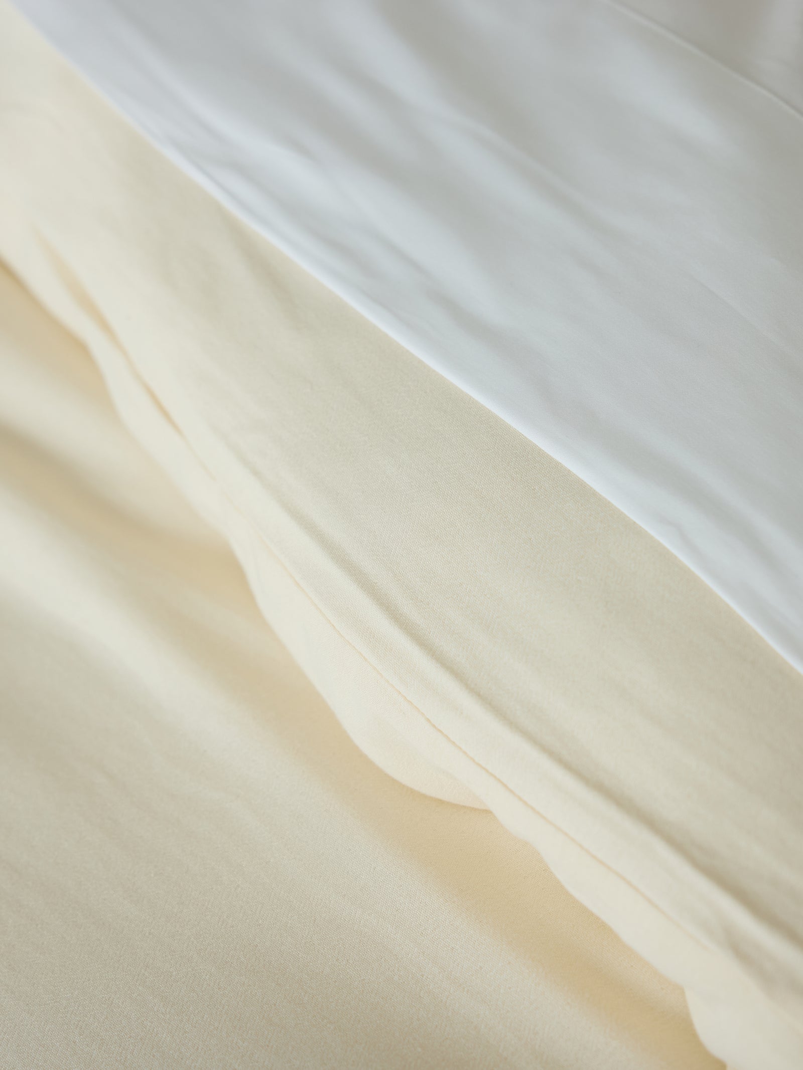 Buttermilk Aire Bamboo Duvet Cover. The Duvet Cover has been photographed on a bed in a home bedroom.