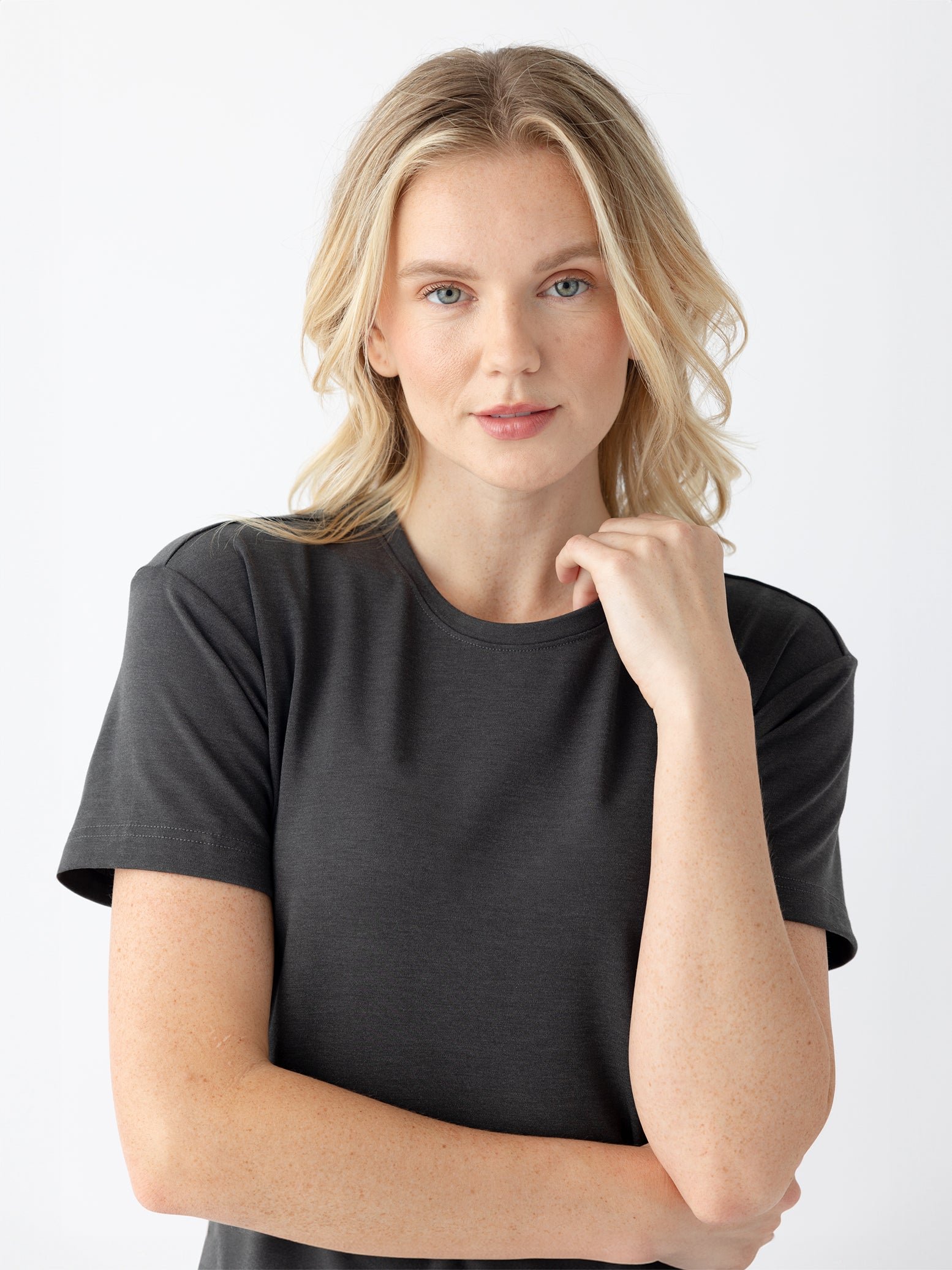 Close up of woman in charcoal midi dress with white background 