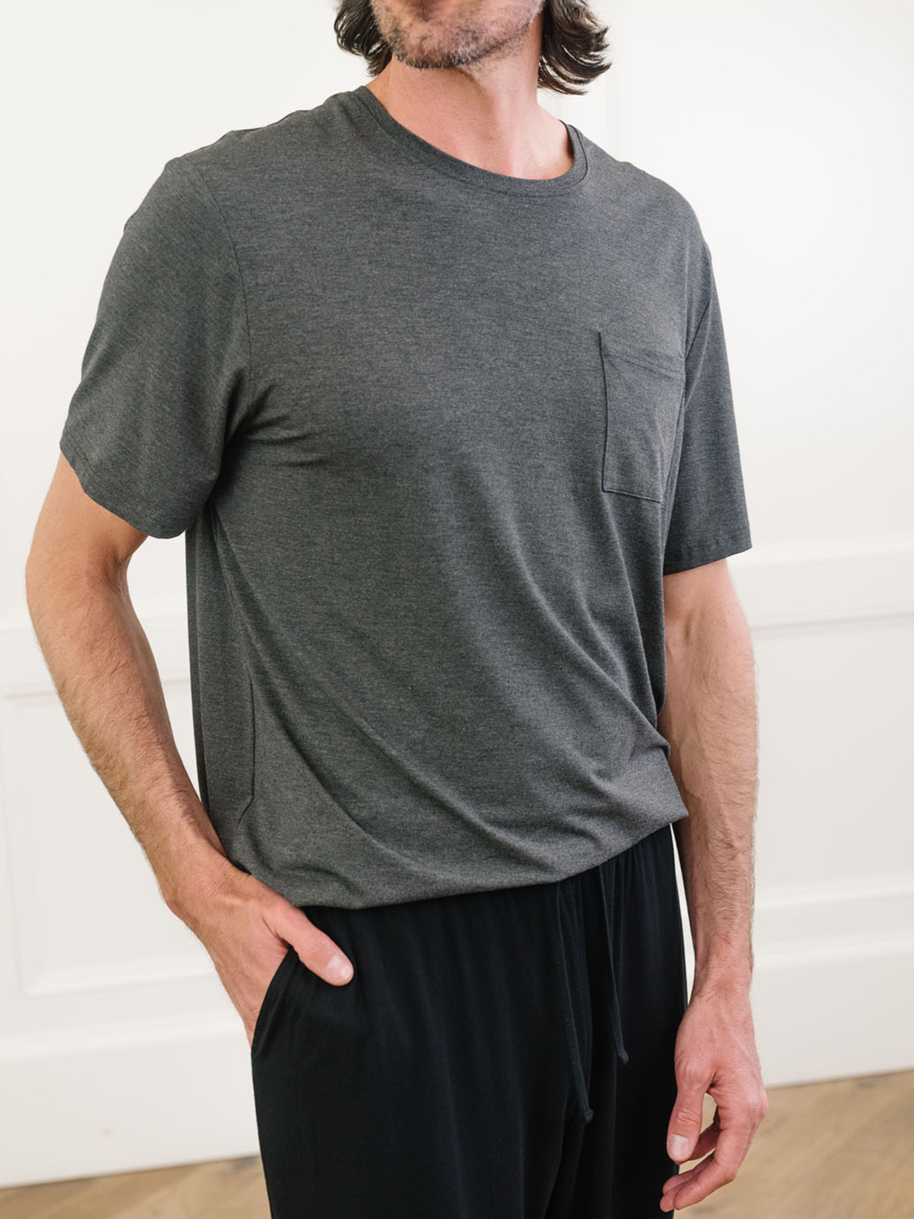 Charcoal Men's Stretch-Knit Bamboo Lounge Tee. A man is wearing the lounge tee in a well lit home.|Color:Charcoal