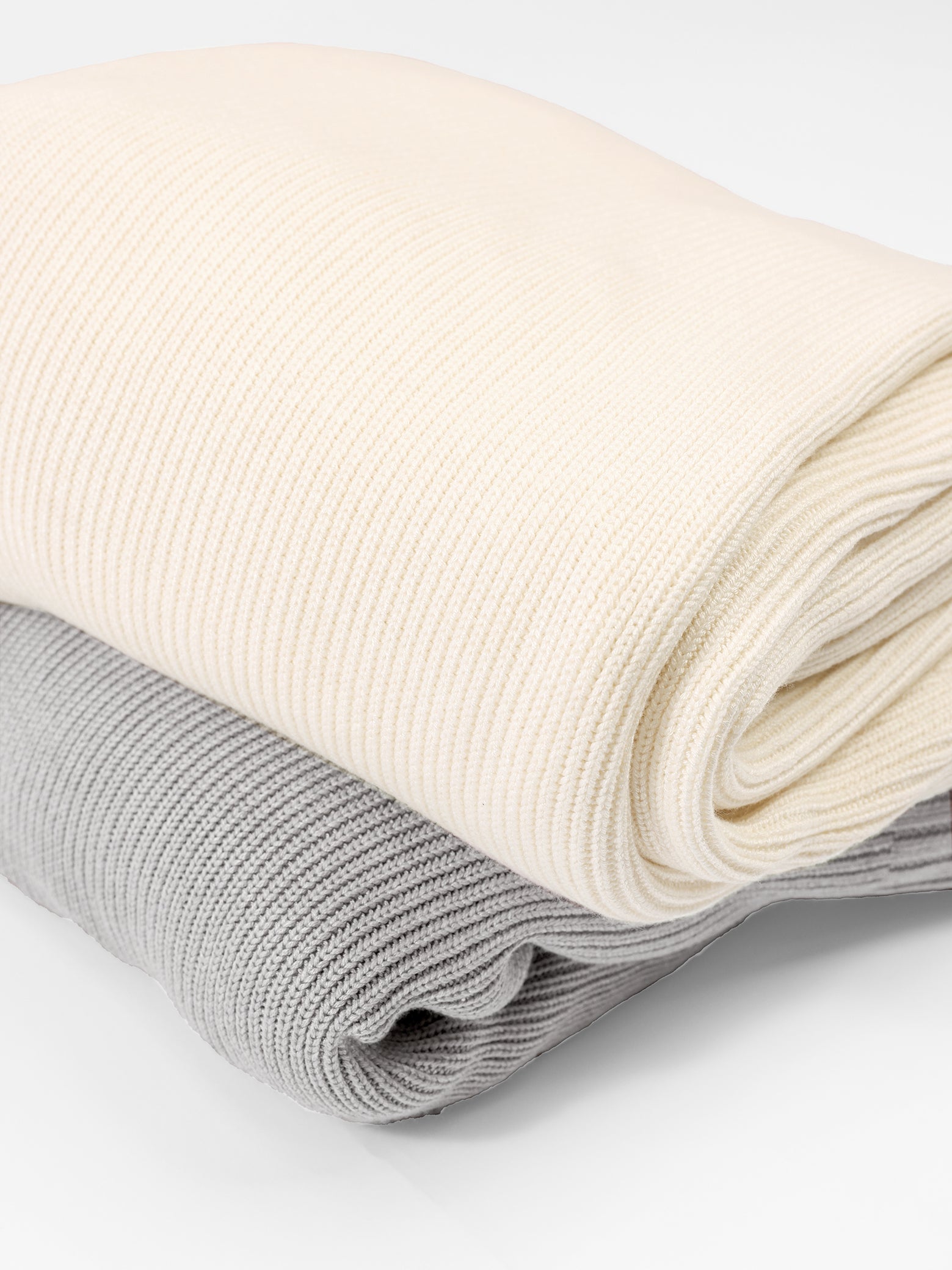 Creme and Dove Grey Classic Knit Blanket neatly folded over background. 