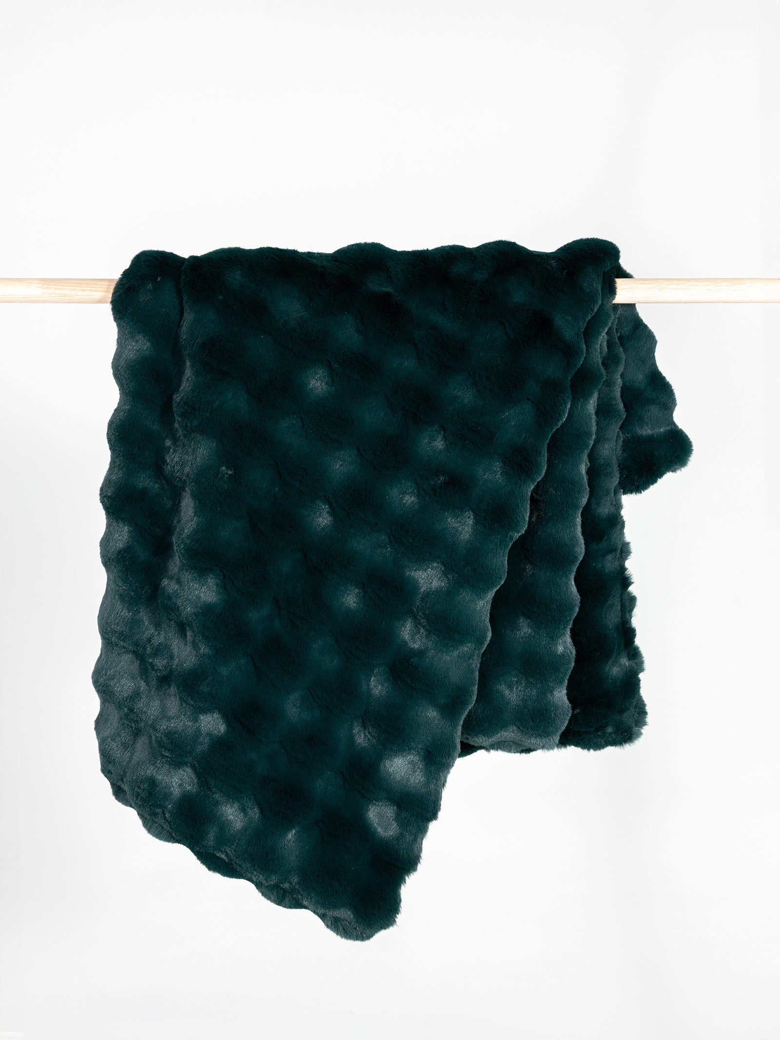 Emerald bubble cuddle blanket draped over wooden pole 