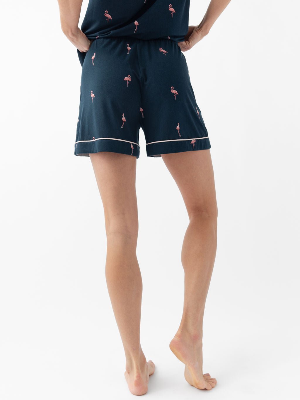Woman wearing flamingo print pajama shorts with white background 