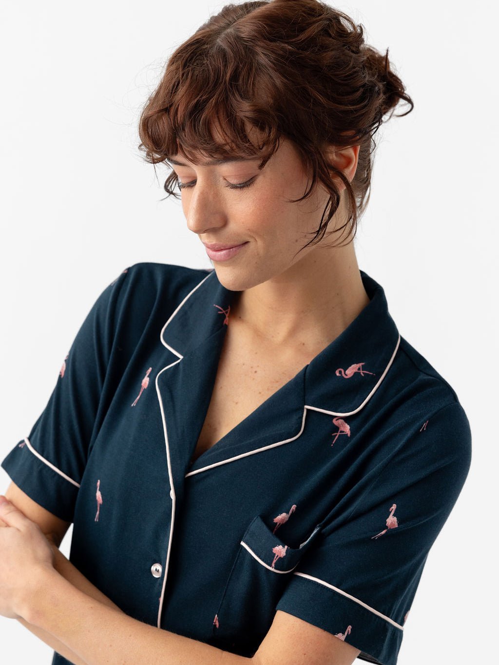 Woman wearing short sleeve flamingo print pajama top with white background 