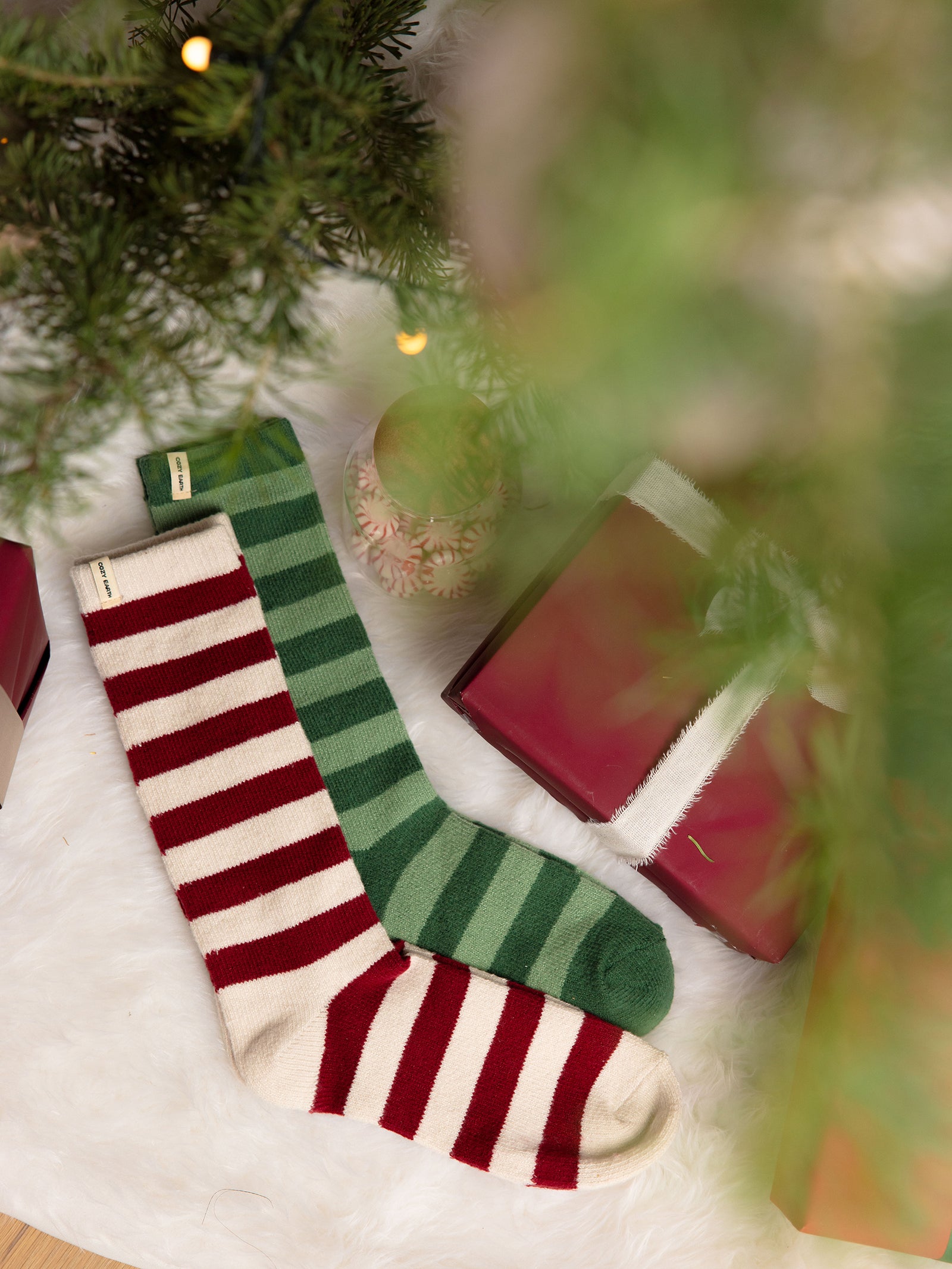 Striped Plush Lounge Socks in Jade and Garnet lying under a Christmas Tree 